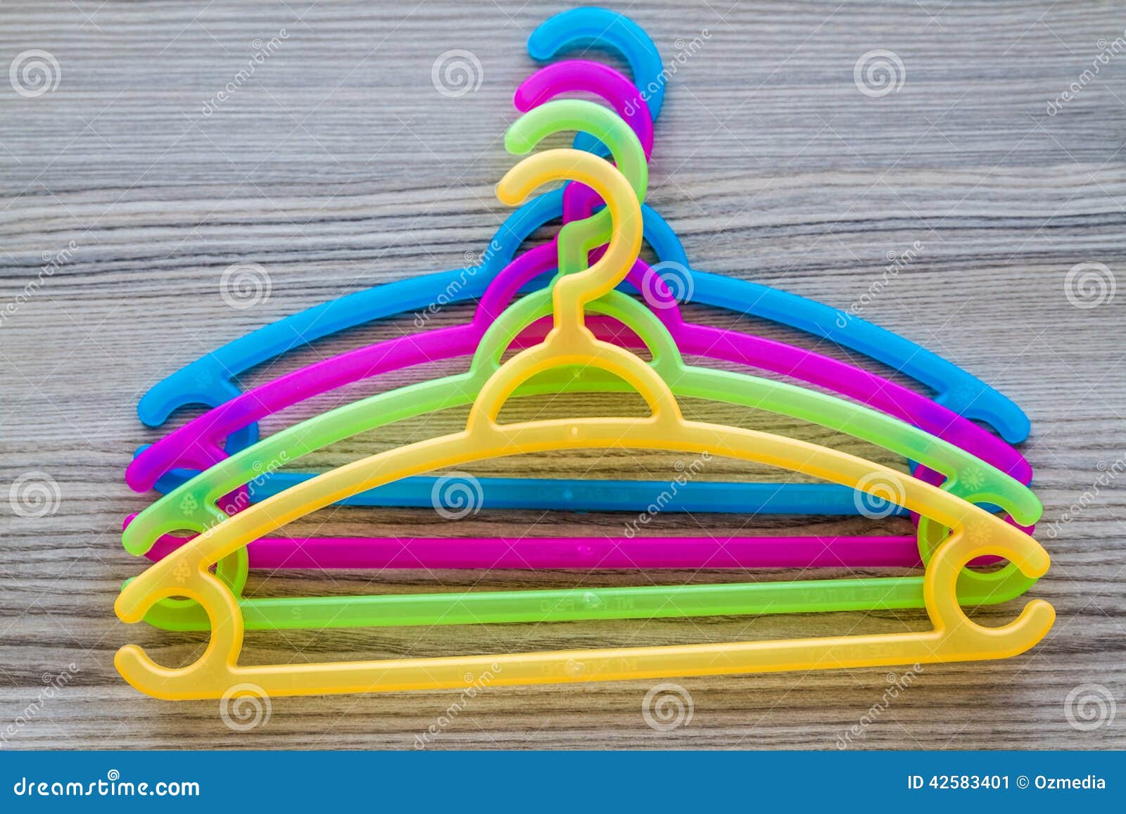 Colorful Clothes Hanger. Colorful modern plastic clothes hanger on a wooden background