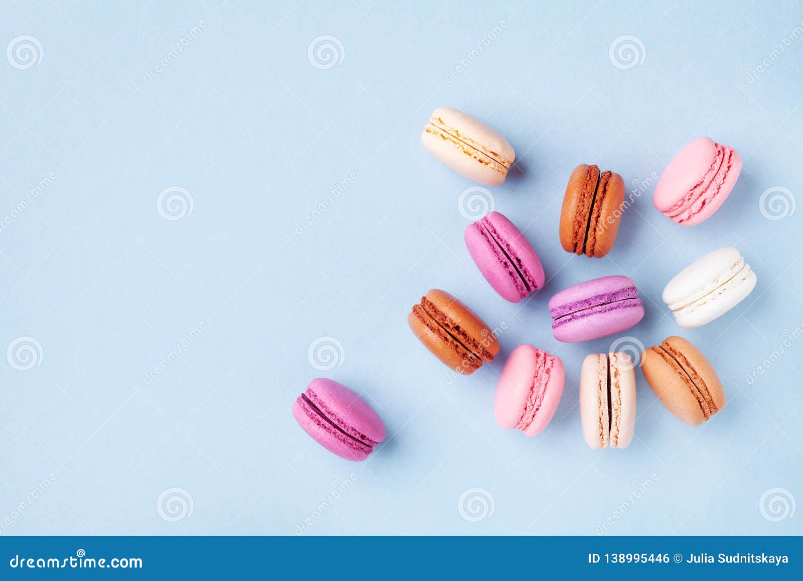Colorful dessert macaron or macaroon on blue background top view. Flat lay style