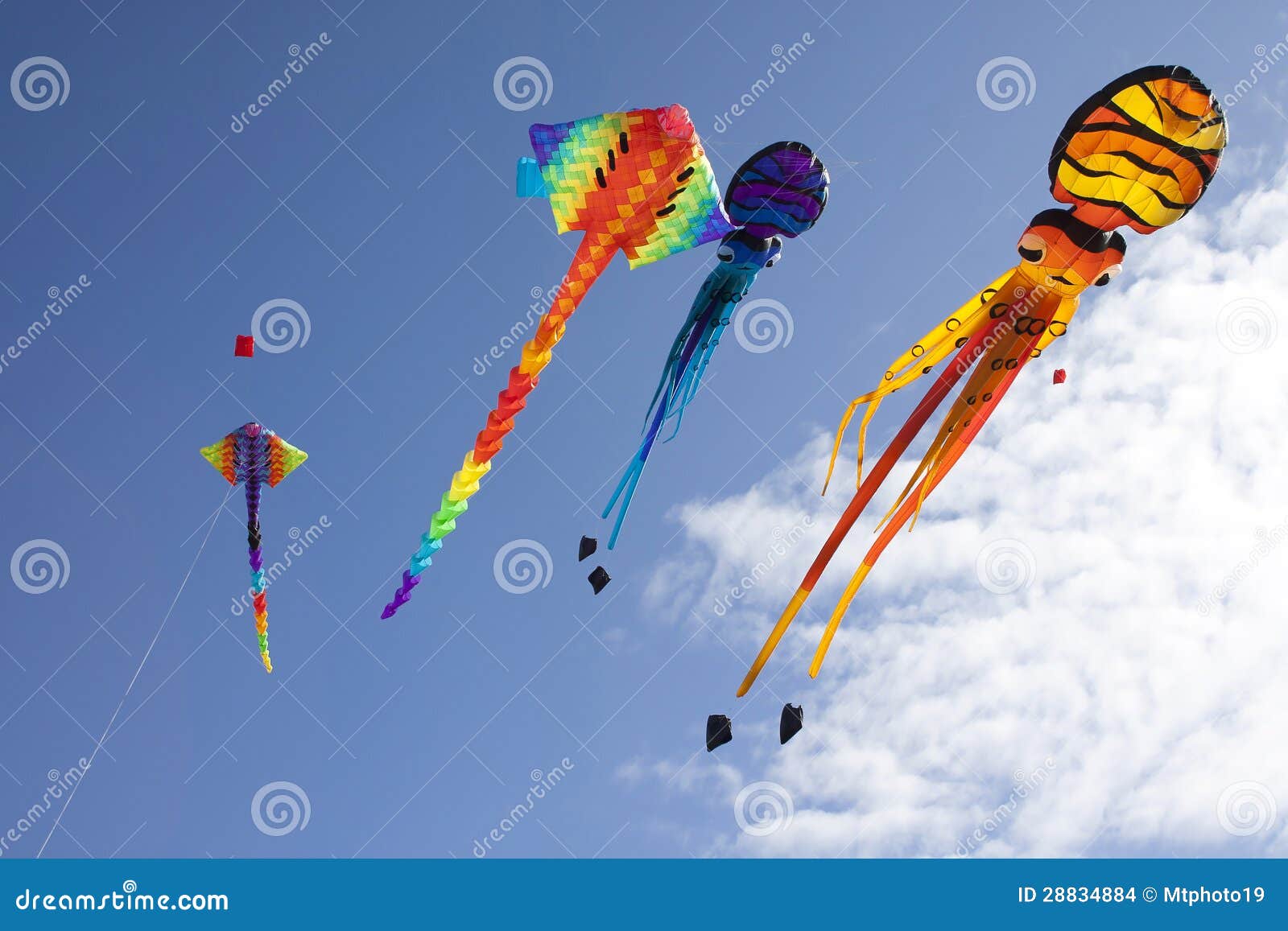 colorful flying kites against a blue sky