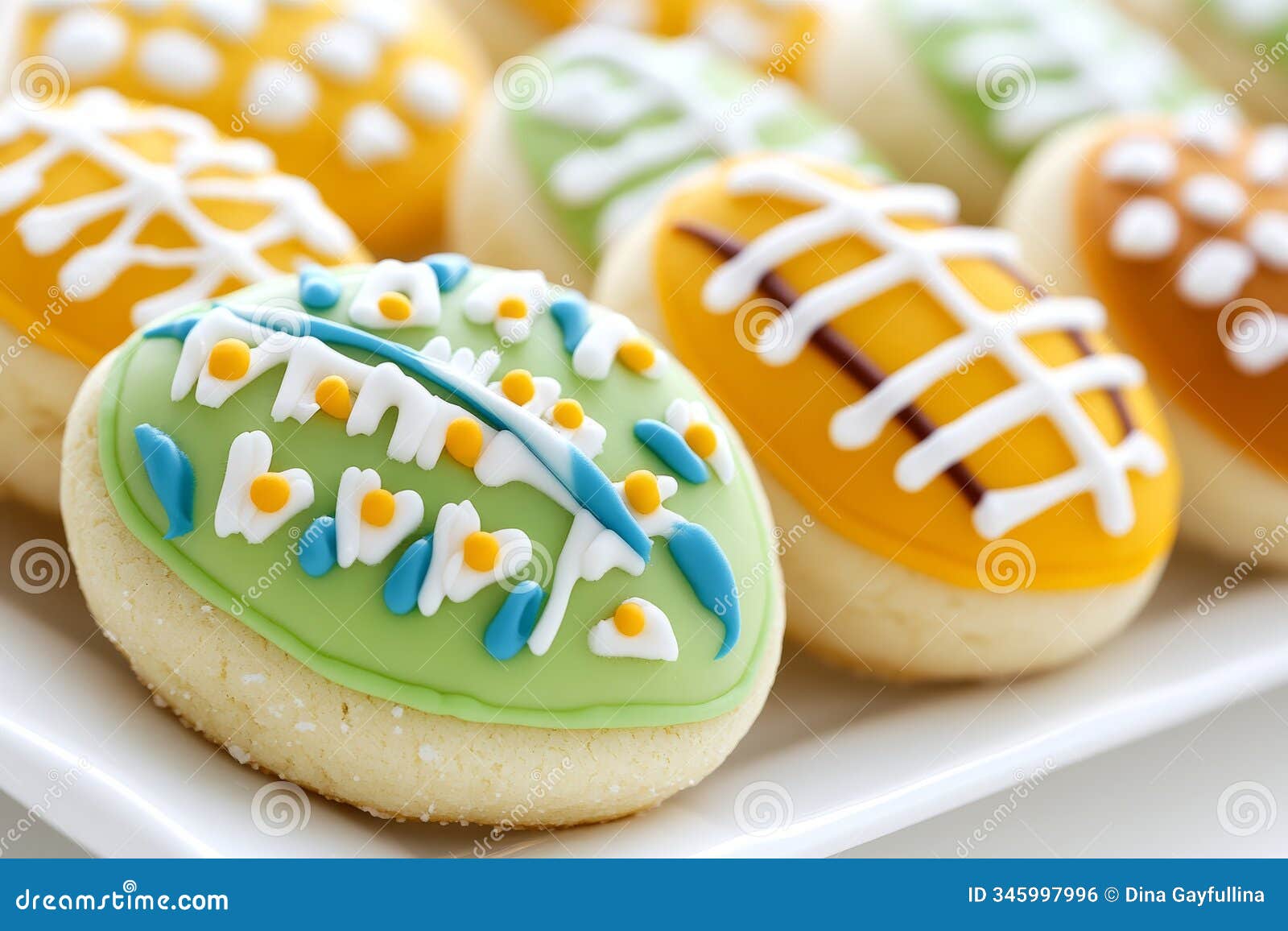 colorful football-d cookies with icing decorations arranged on a plate.