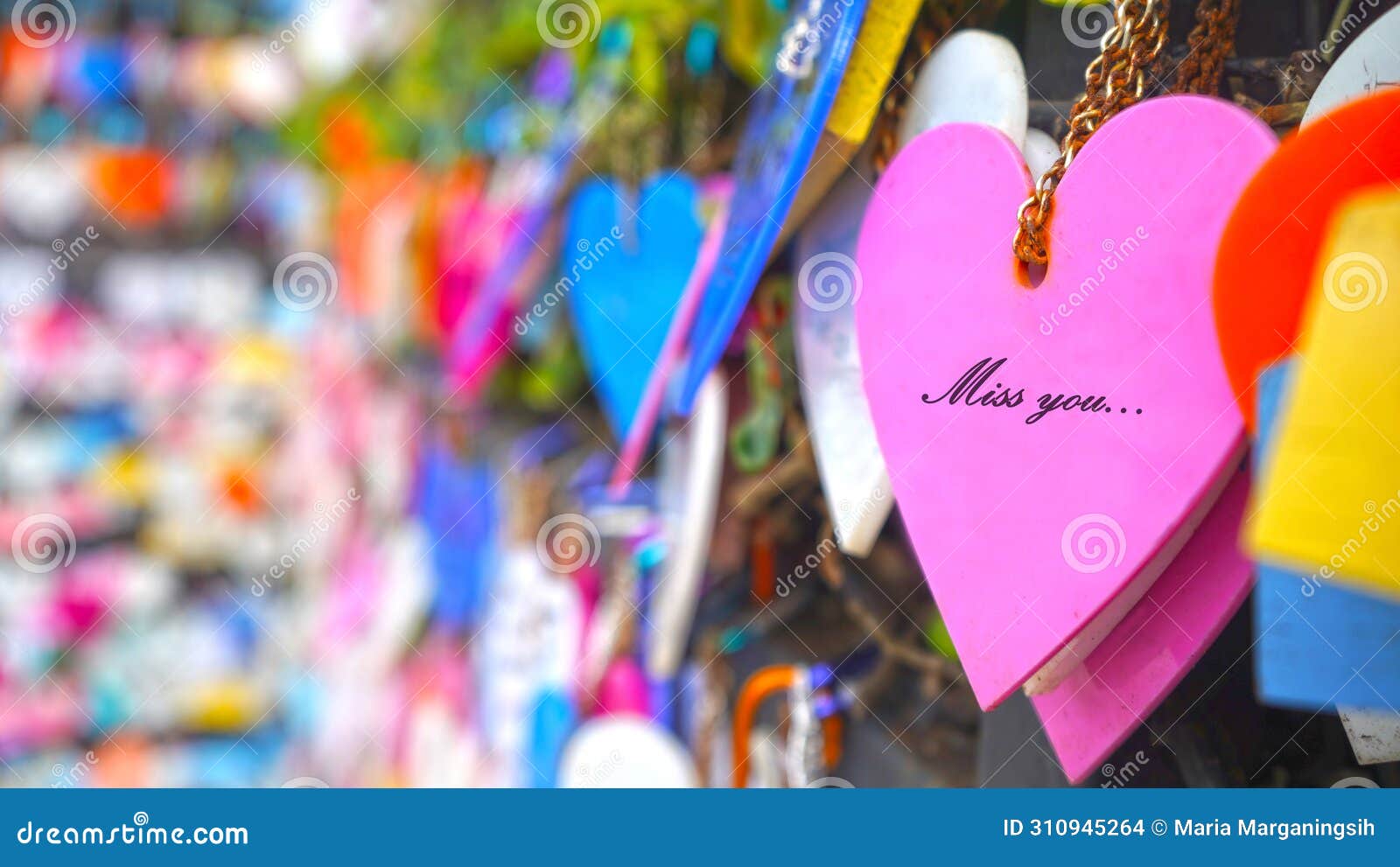colorful hearts on the street hanging on wall with random love text messages - miss you