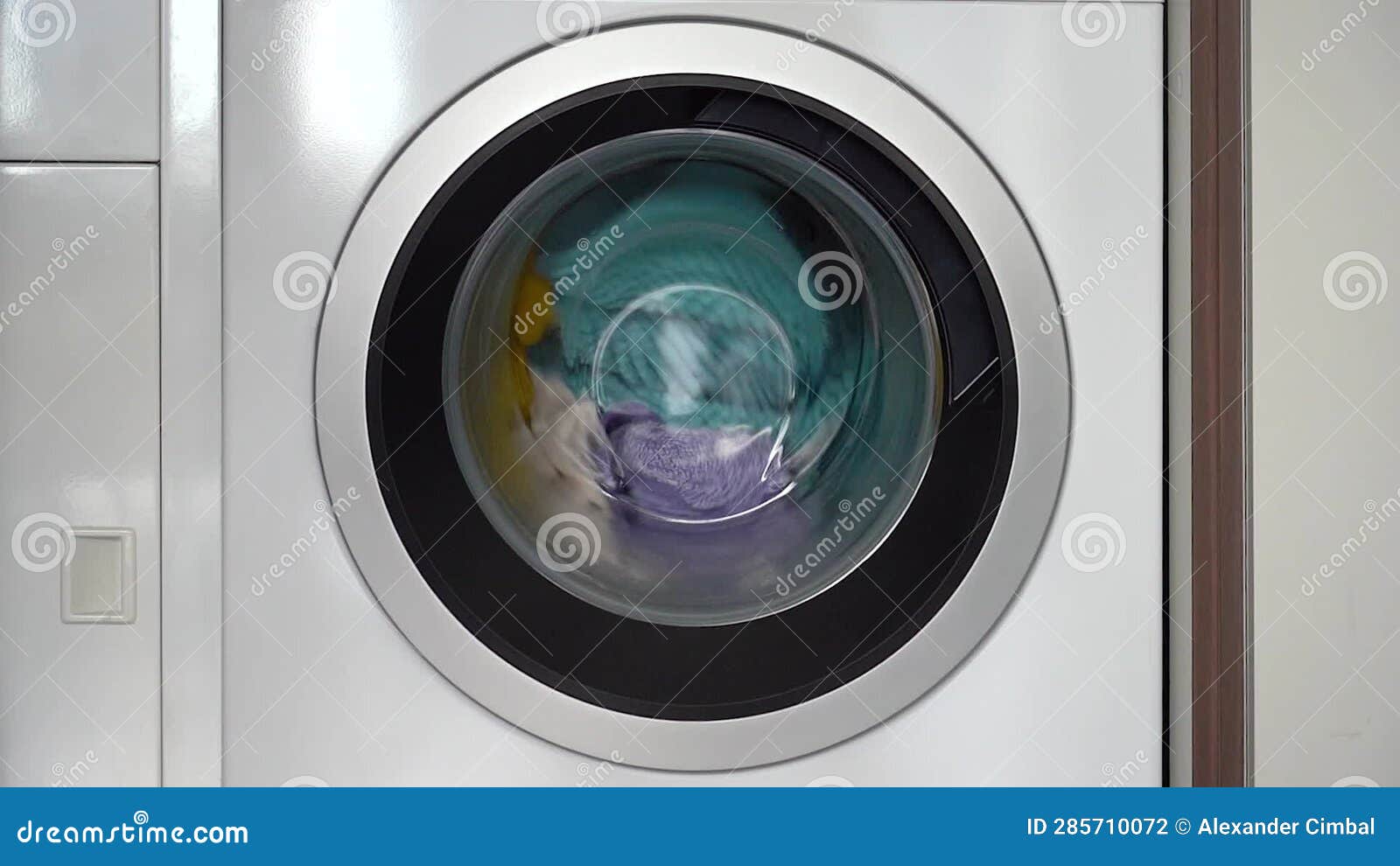 Colorful Laundry Inside a Front Loader Washing Machine Spinning
