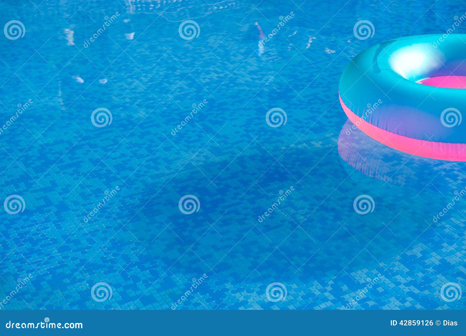 Colorful Life Preserver Floating in a Crystal Clear Pool Stock Photo
