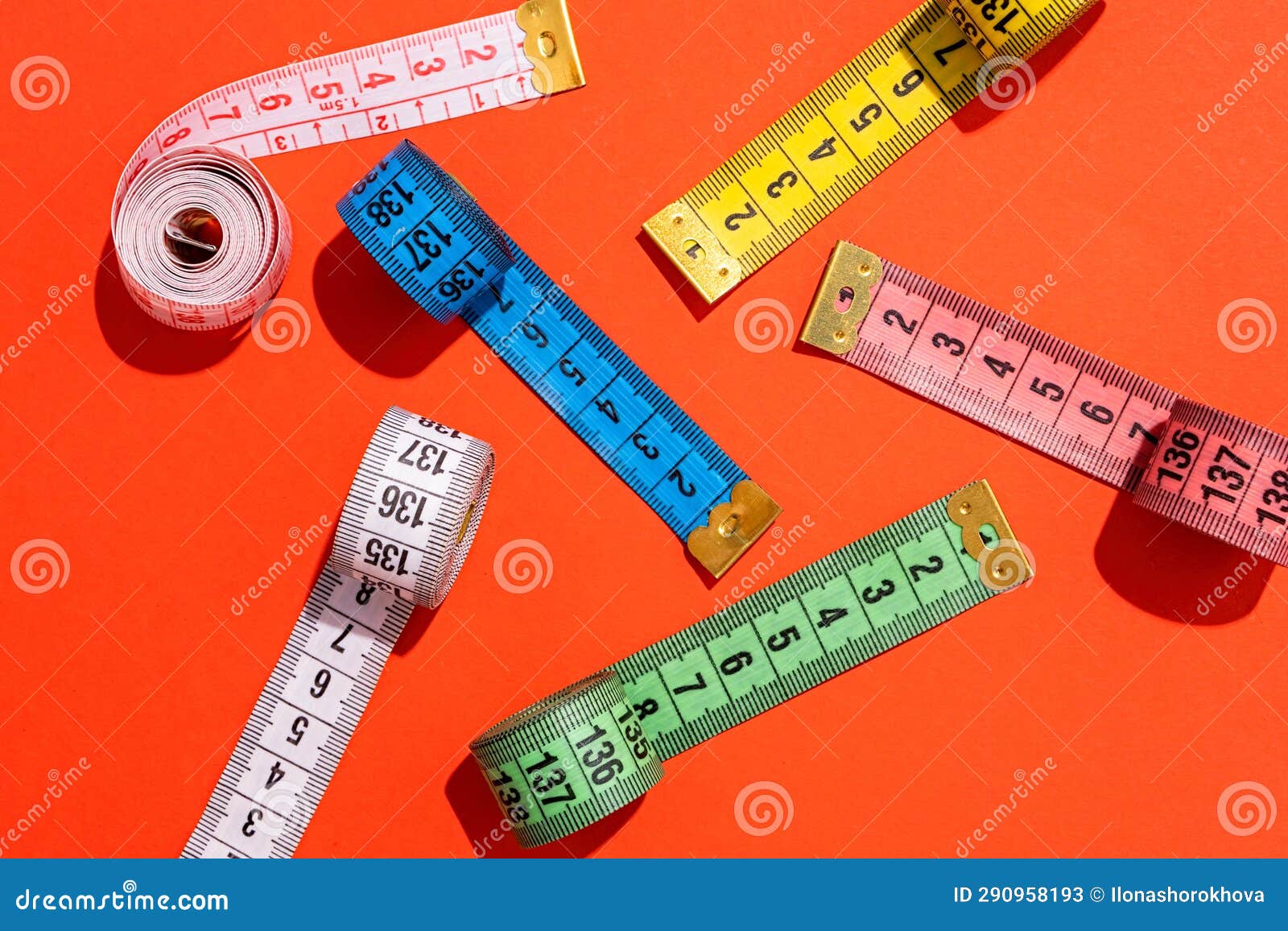 Colorful Measuring Tapes Top View on Bright Red Background Stock Image