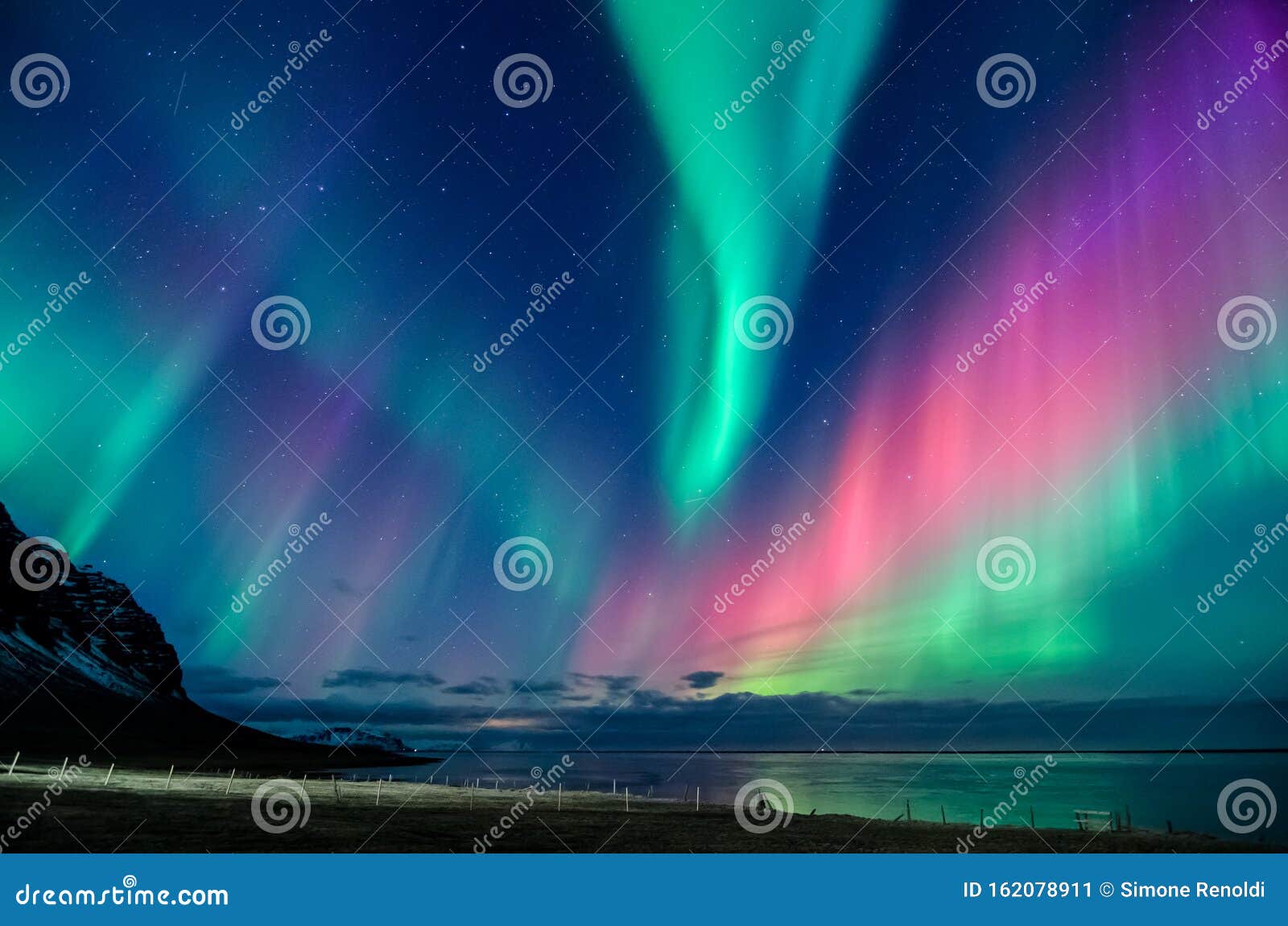 colorful northern lights spiral in a iceland beach