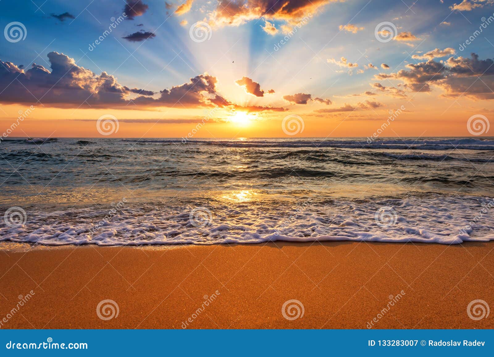 colorful ocean beach sunrise with deep blue sky and sun rays