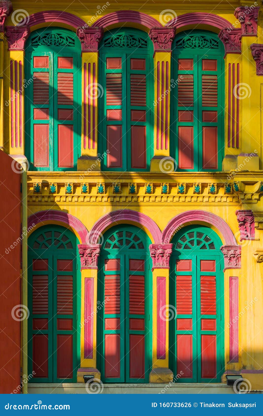 colorful old green and red wooden window on yellow cement wall beautiful exterior architeture in the capital town singapore