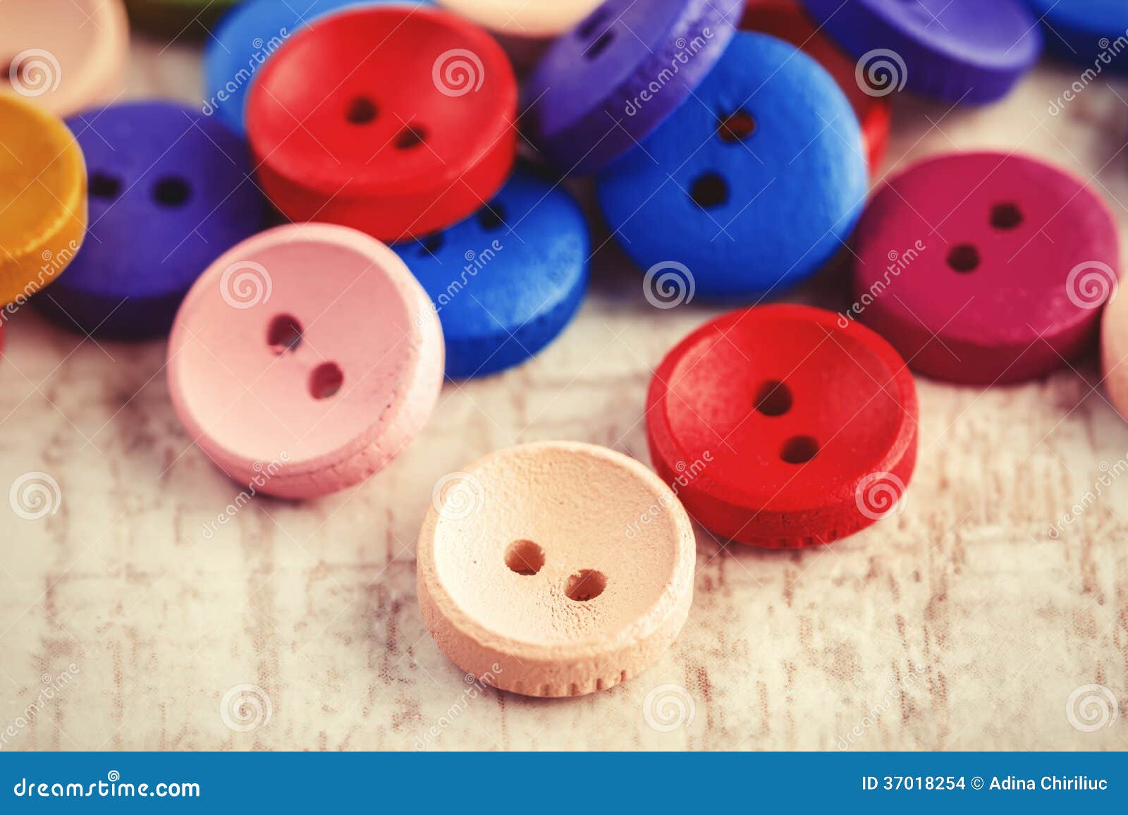 Lots of colorful buttons for clothes on wooden background