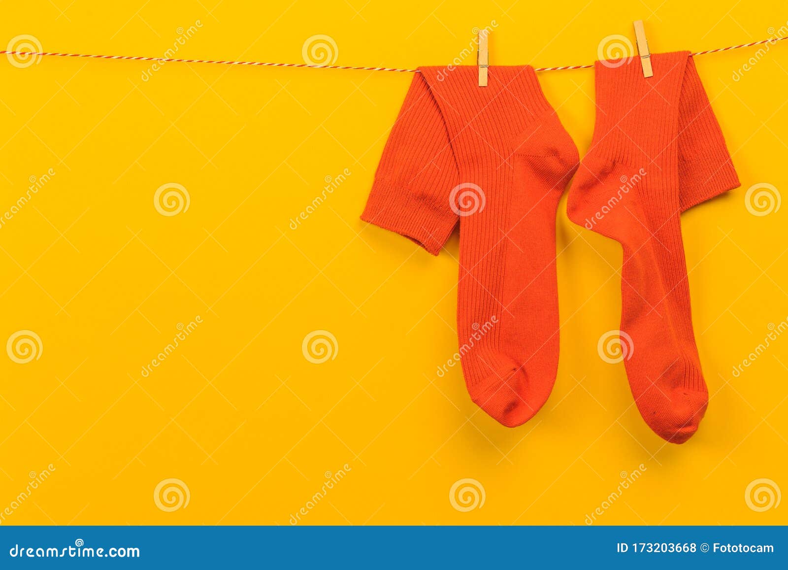 Colorful Orange Socks Hanging on a Rope on Yellow Background - Image ...