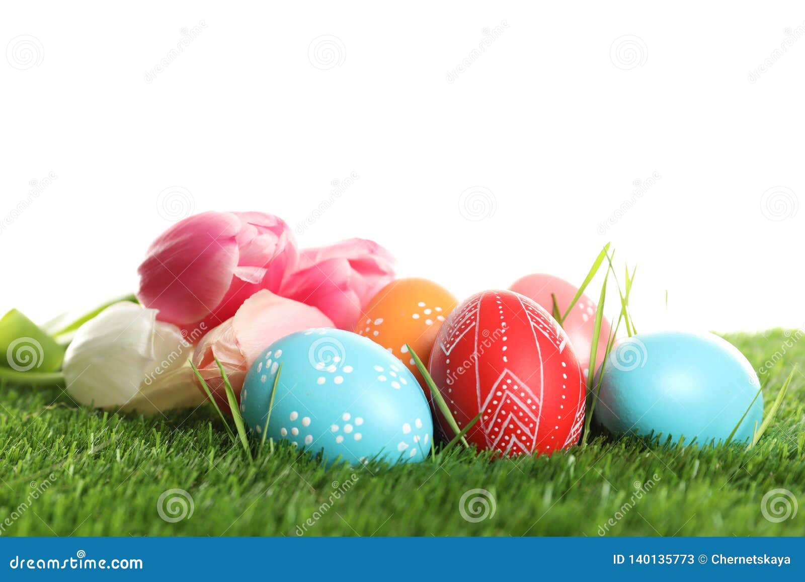 Colorful Painted Easter Eggs and Spring Flowers on Green Grass Stock