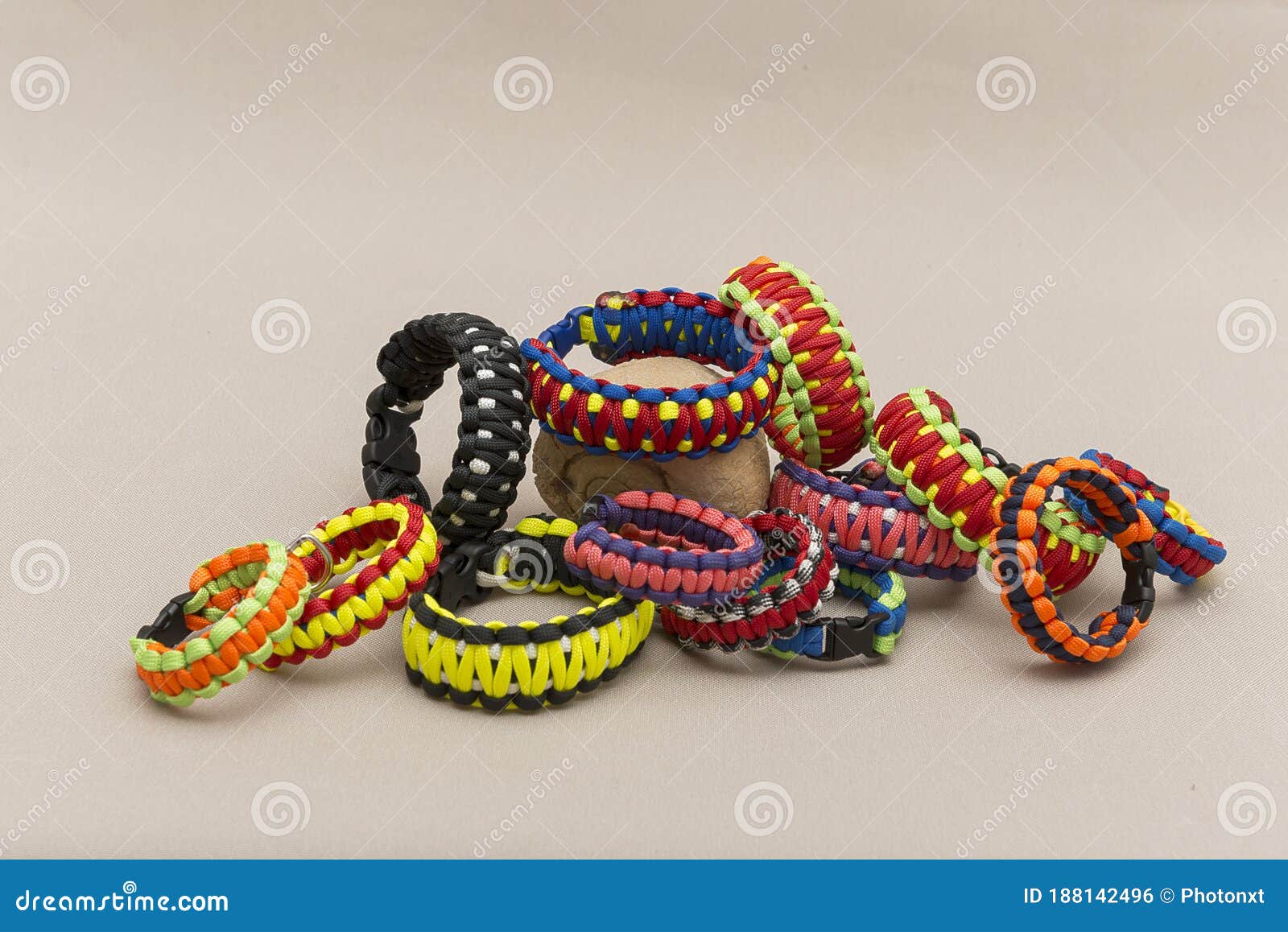 Colorful Paracord Bracelet Placed Near A Fossilized Shell, Isolated On A Light Brown Background ...