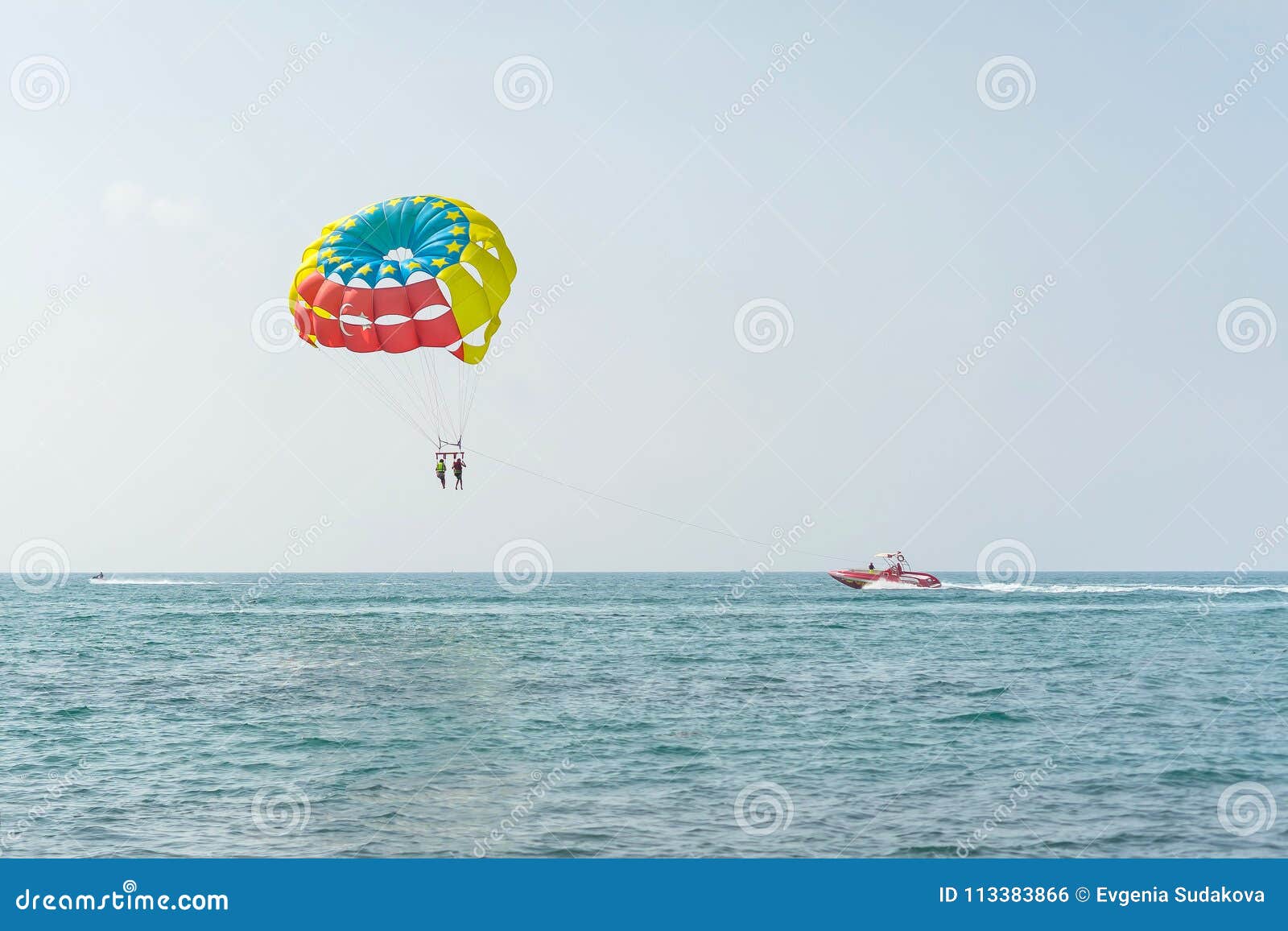colorful parasail wing pulled by a boat in the sea water - alanya, turkey