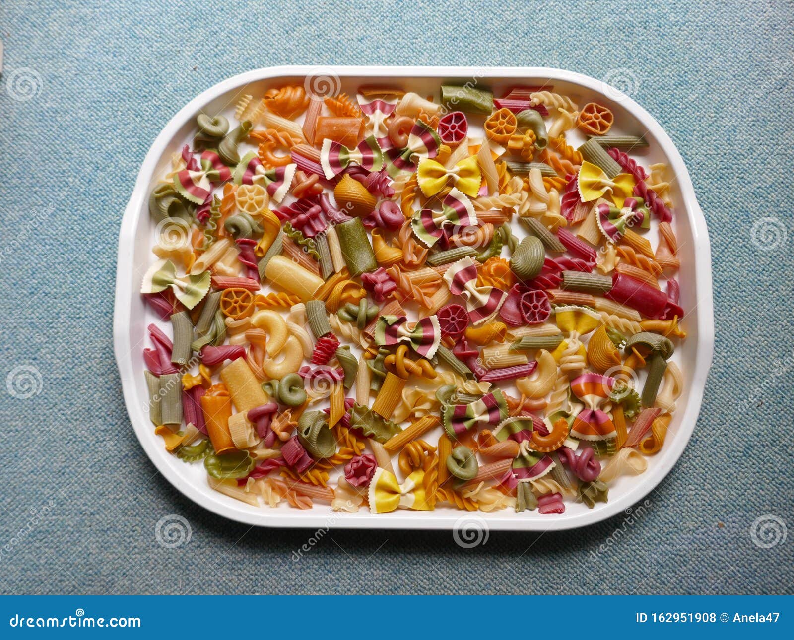 Colorful Pasta, Loop Noodles, Italian Pasta, Farfalle, Fusilli, Penne and  Others on a White Tablet Against a Neutral Background. Stock Photo - Image  of carbohydrates, decoration: 162951908