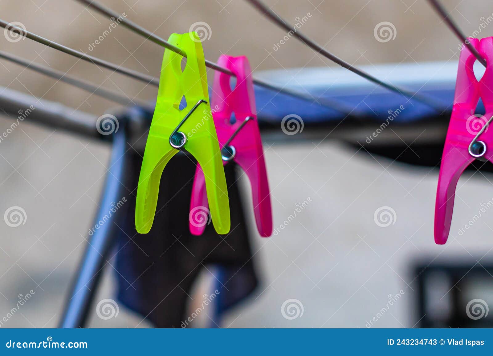 Colorful Plastic Clothes Pegs on Empty Metal Clothes Dryer Stock Image