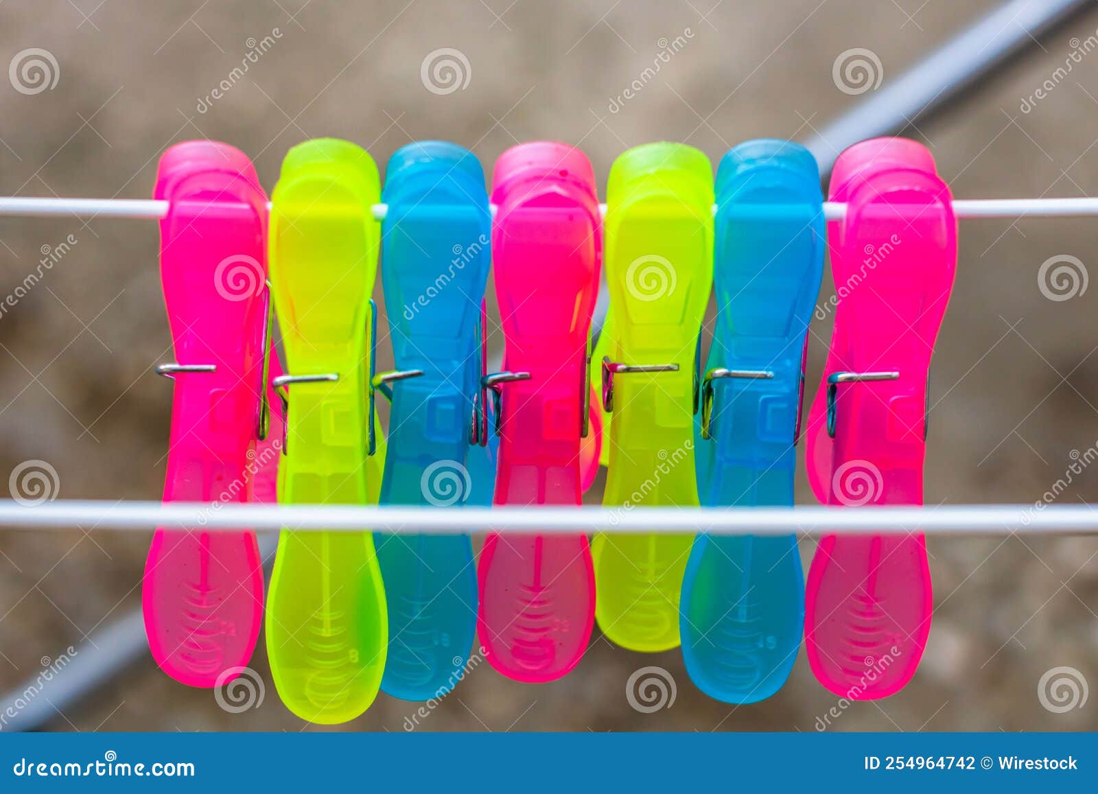 Colorful Plastic Clothes Pegs on the Empty Metal Clothes Dryer Stock