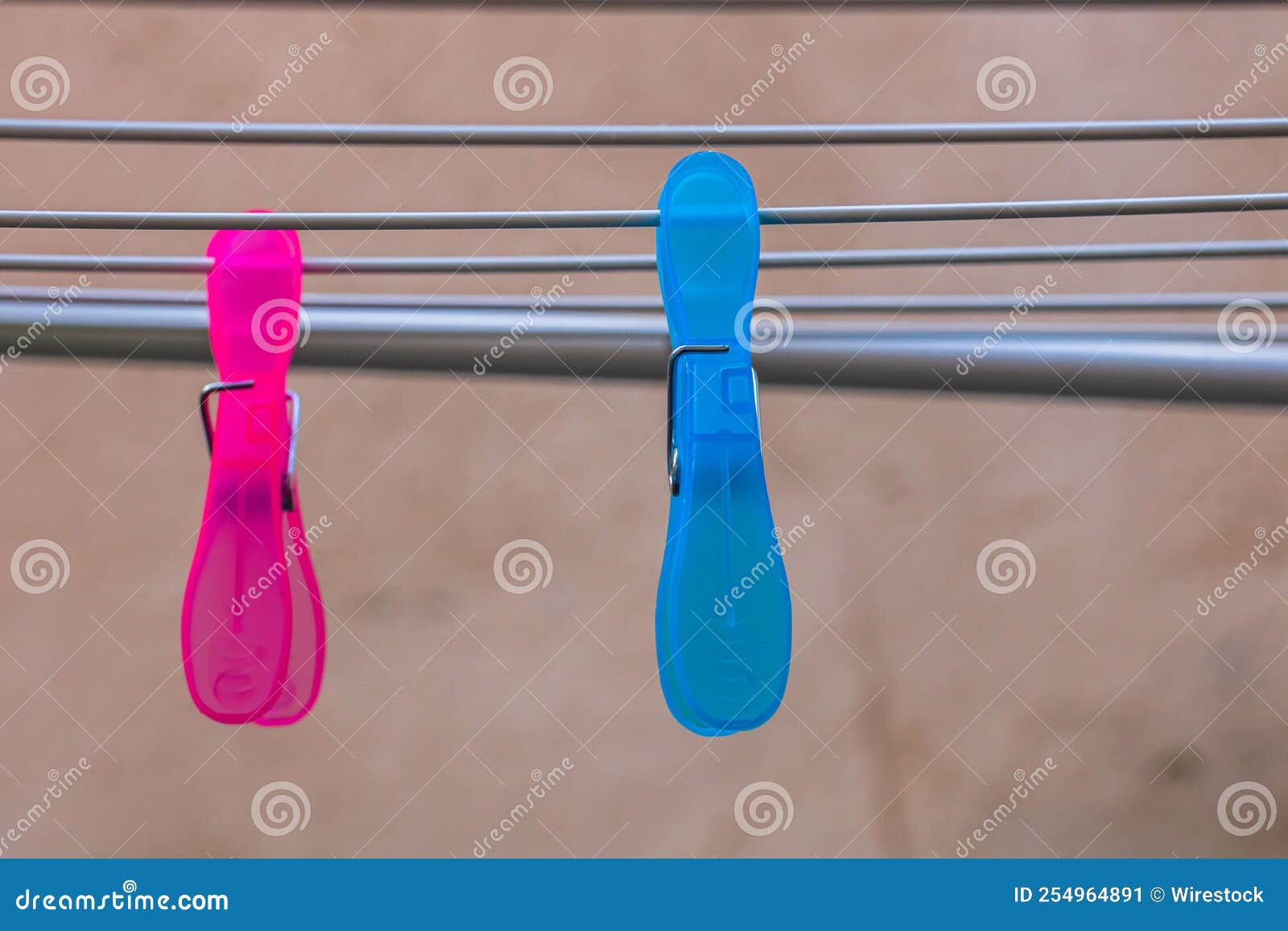 Colorful Plastic Clothes Pegs on the Empty Metal Clothes Dryer Stock