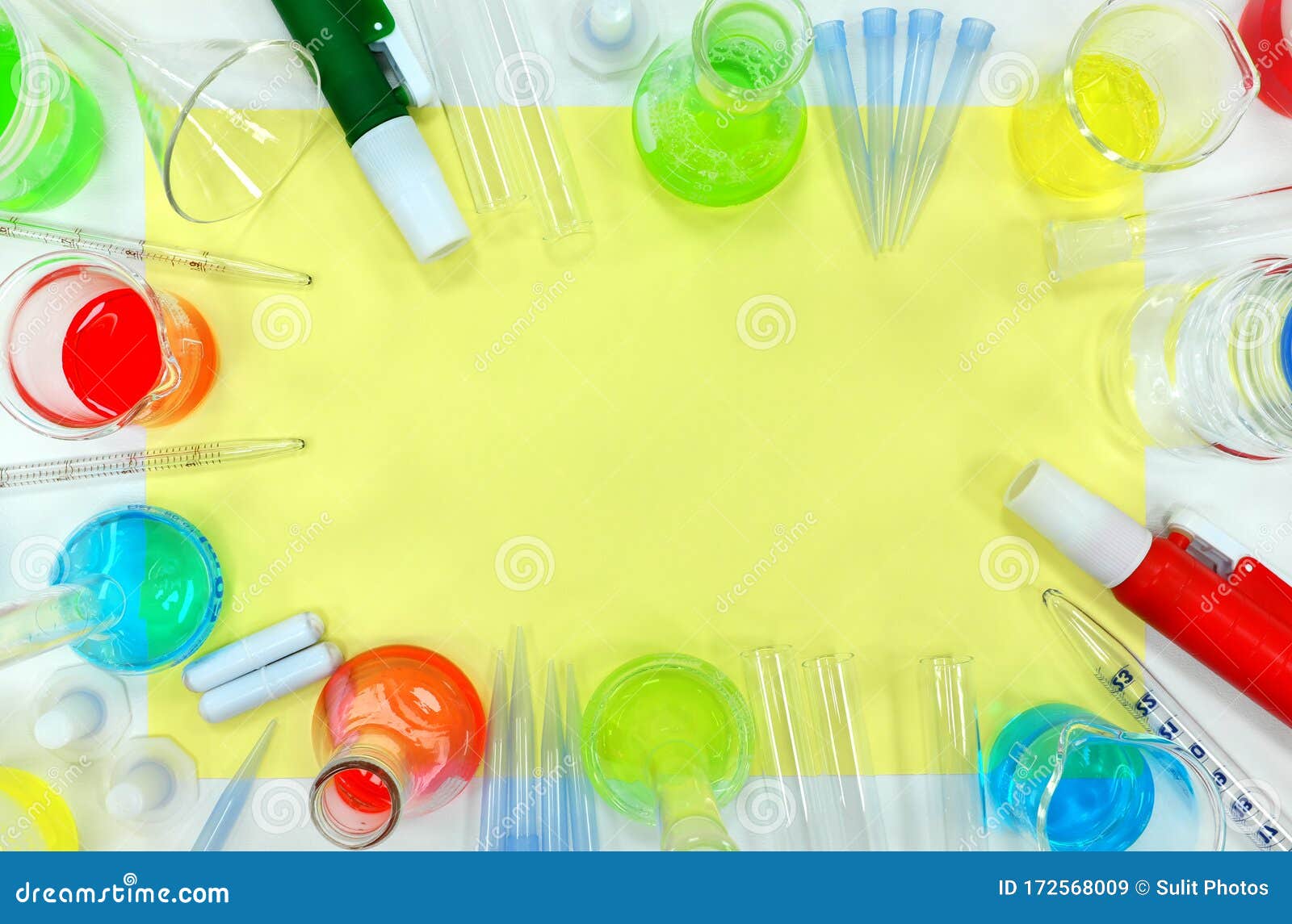 colorful science flat lay composition background. colored chemicals and glasswares frame border with copy space.