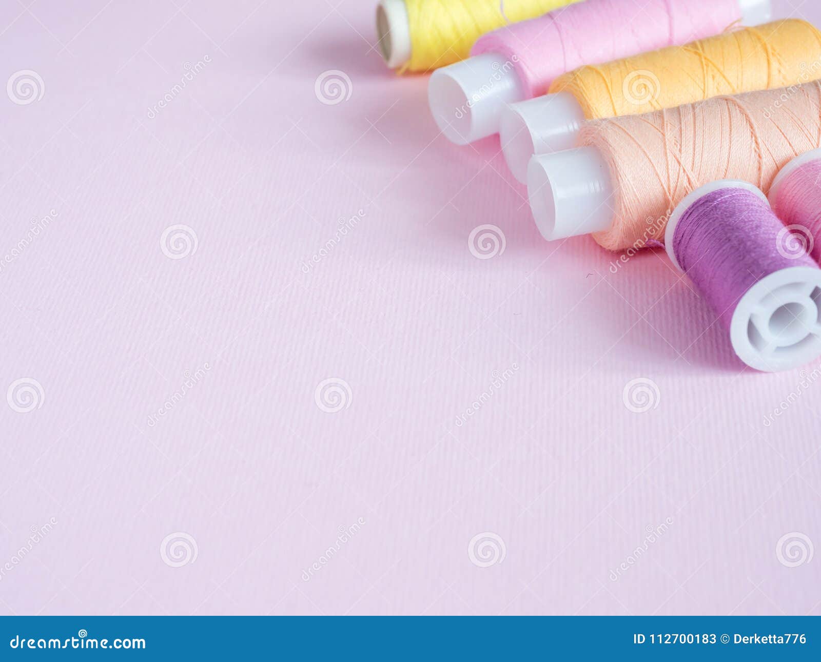 Colorful Sewing Buttons and Thread on a Pink Background. Stock Image