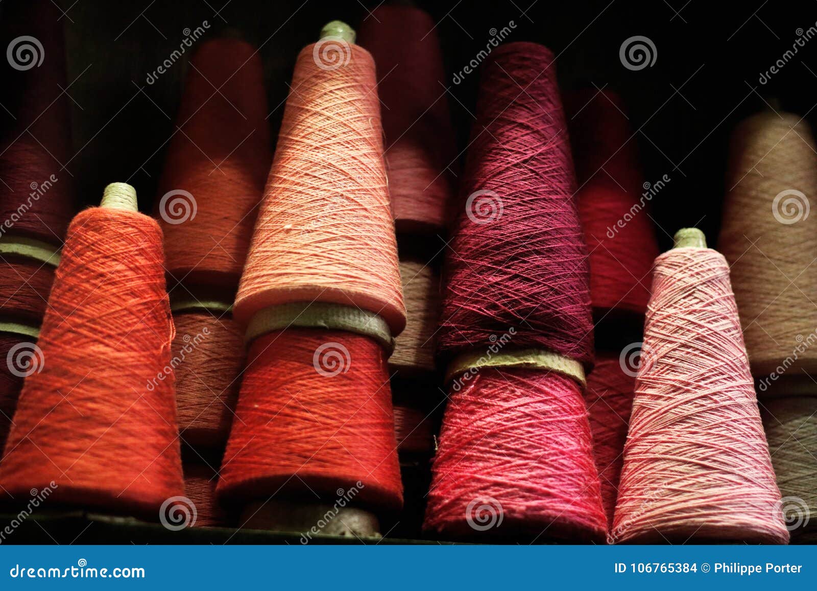 spools of thread red pink background in a vintage shop in paris france