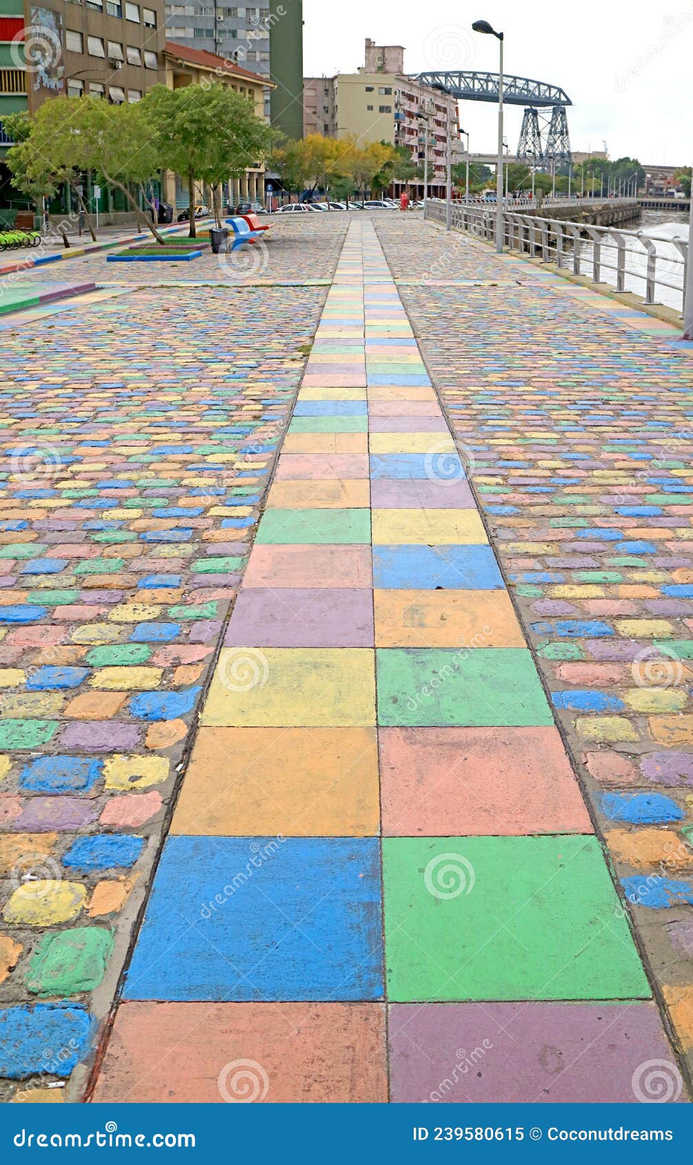 colorful walking path by the riachuelo river with the former buenos aires transporter bridge in backdrop, la boca, buenos aires