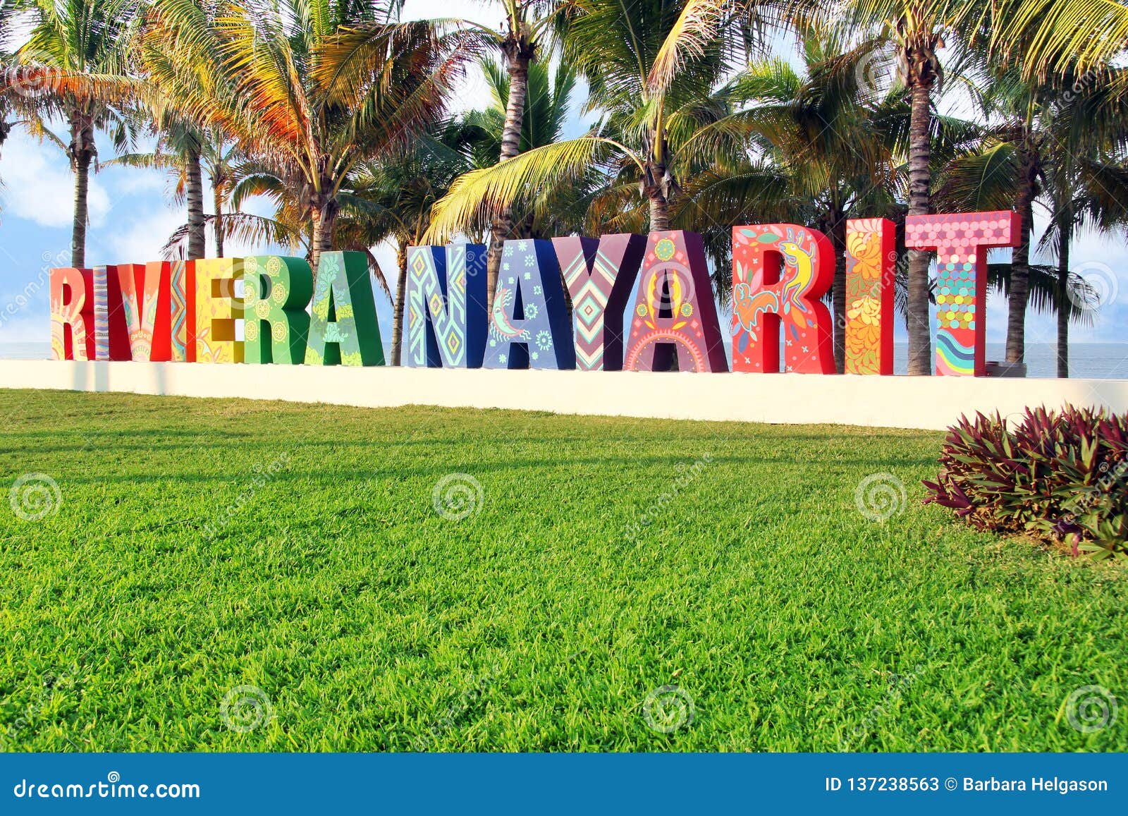 colorfully painted riviera nayarit sign on a public beach in mexico. translation: coastline nayarit.