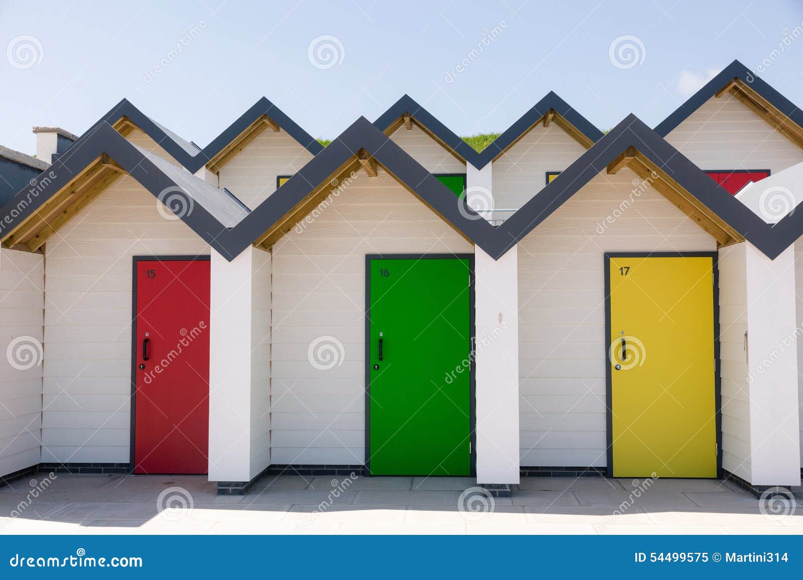 colourful doors of yellow, red and green, , with each one being numbered individually, of white beach houses on a sunny day