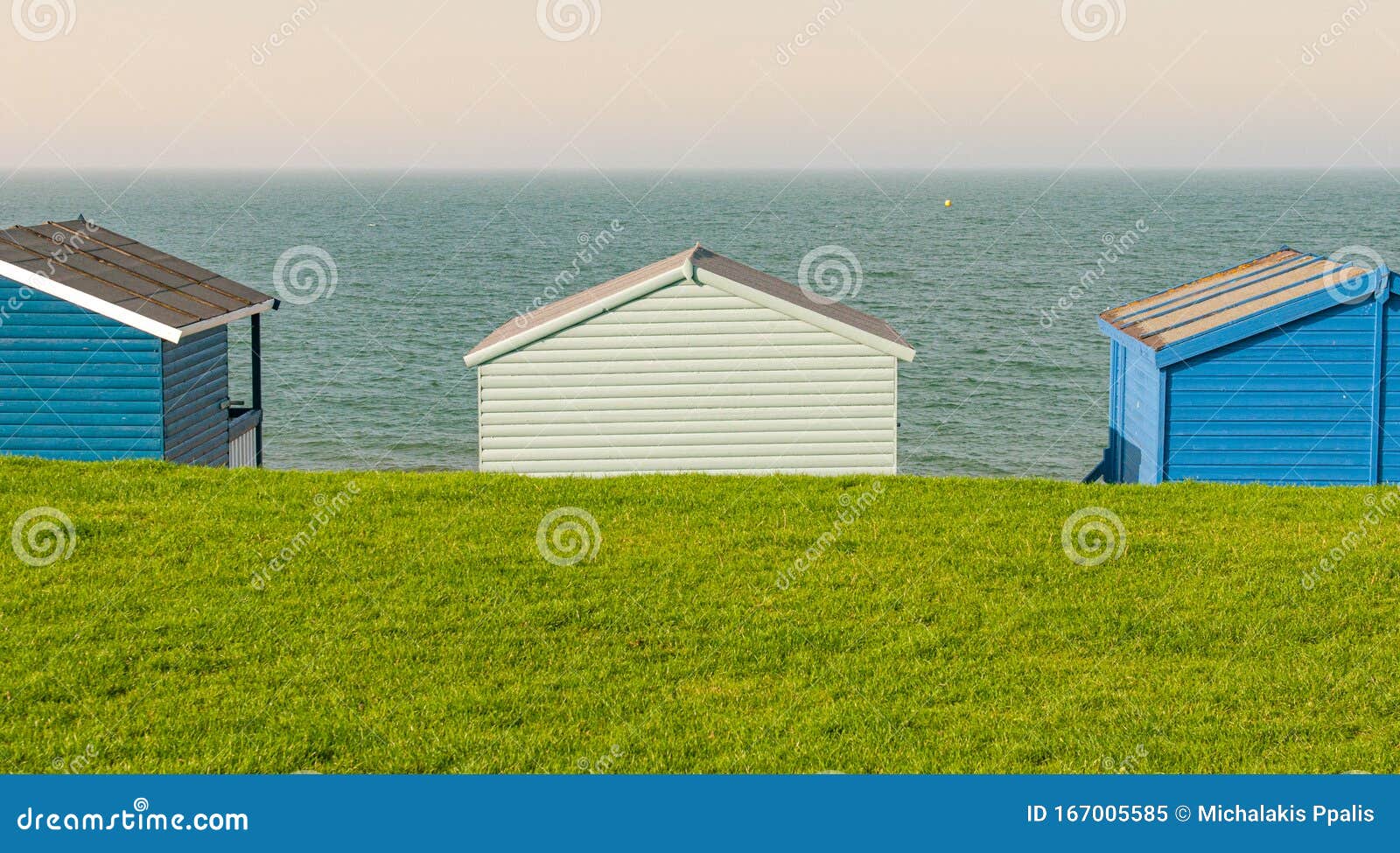 Colourful Holiday Wooden Beach Huts Facing The Calm Ocean Stock Image