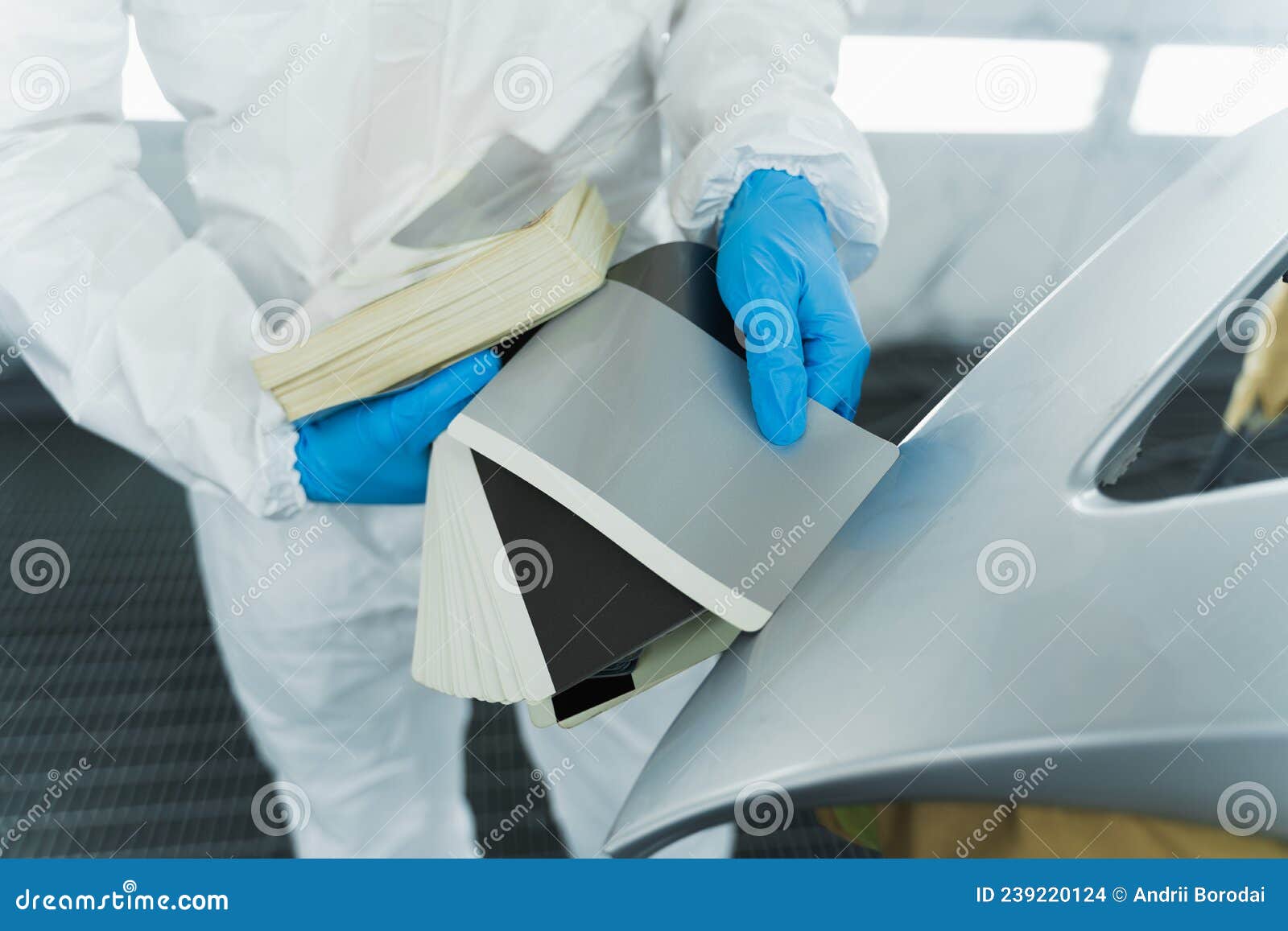 colourist man selecting color of car bumper with paint matching samples.
