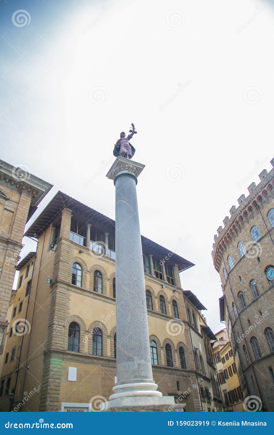 A Column with a Statue at the Top Surrounded by Houses. the Man on the