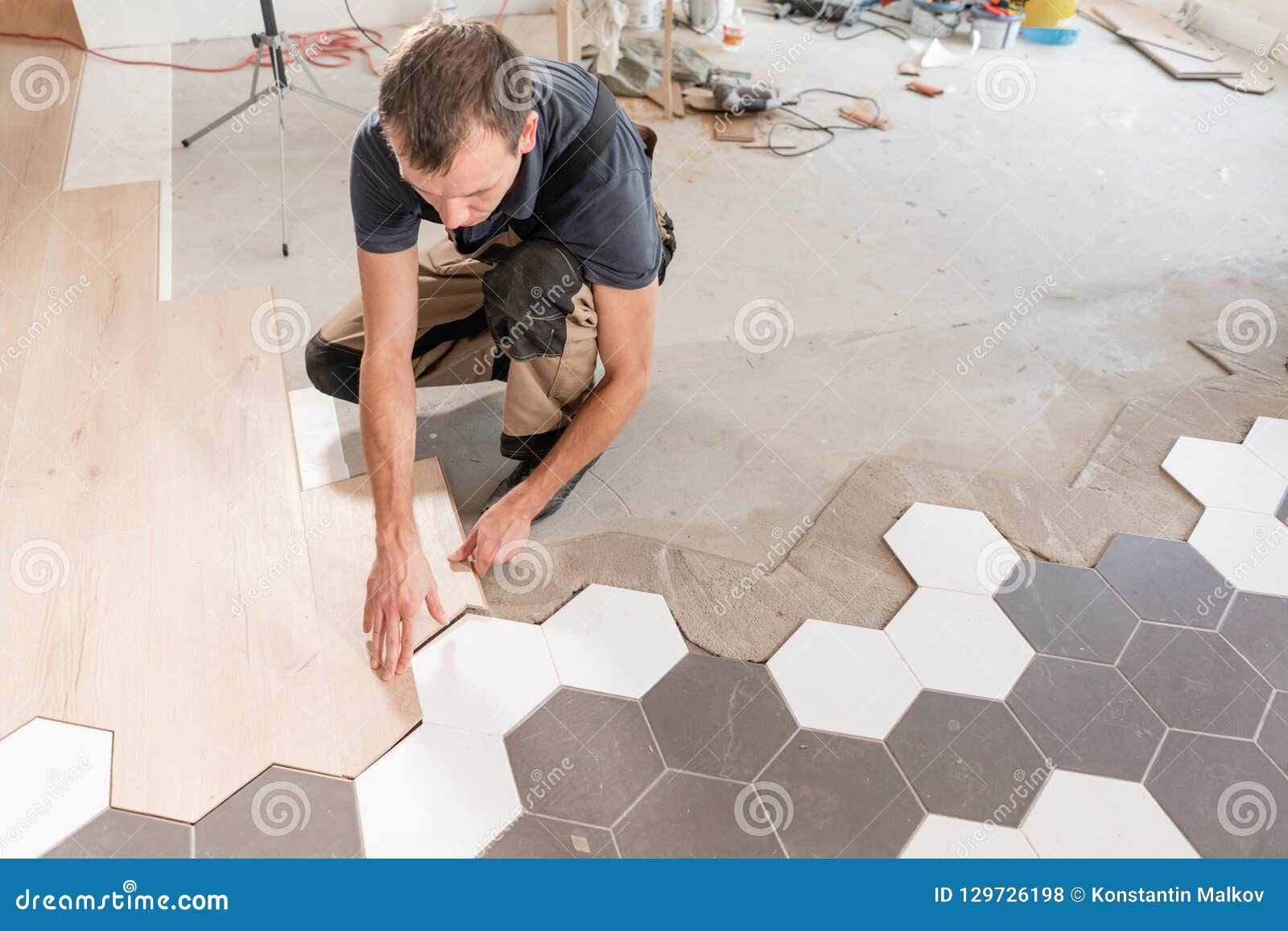 Male Worker Installing New Wooden Laminate Flooring The