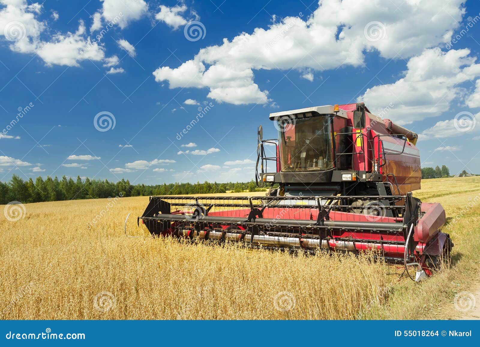 combine machine with air-conditioned cab harvesting oats on farm field