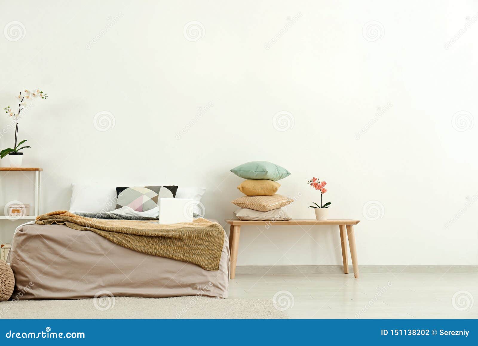 Comfortable Bed with Wooden Table Near Light Wall Stock Photo Image
