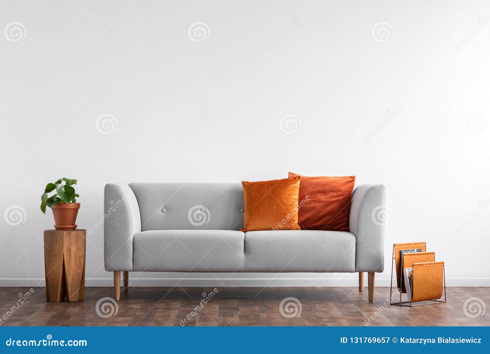 comfortable couch with orange and red pillow in spacious living room interior,