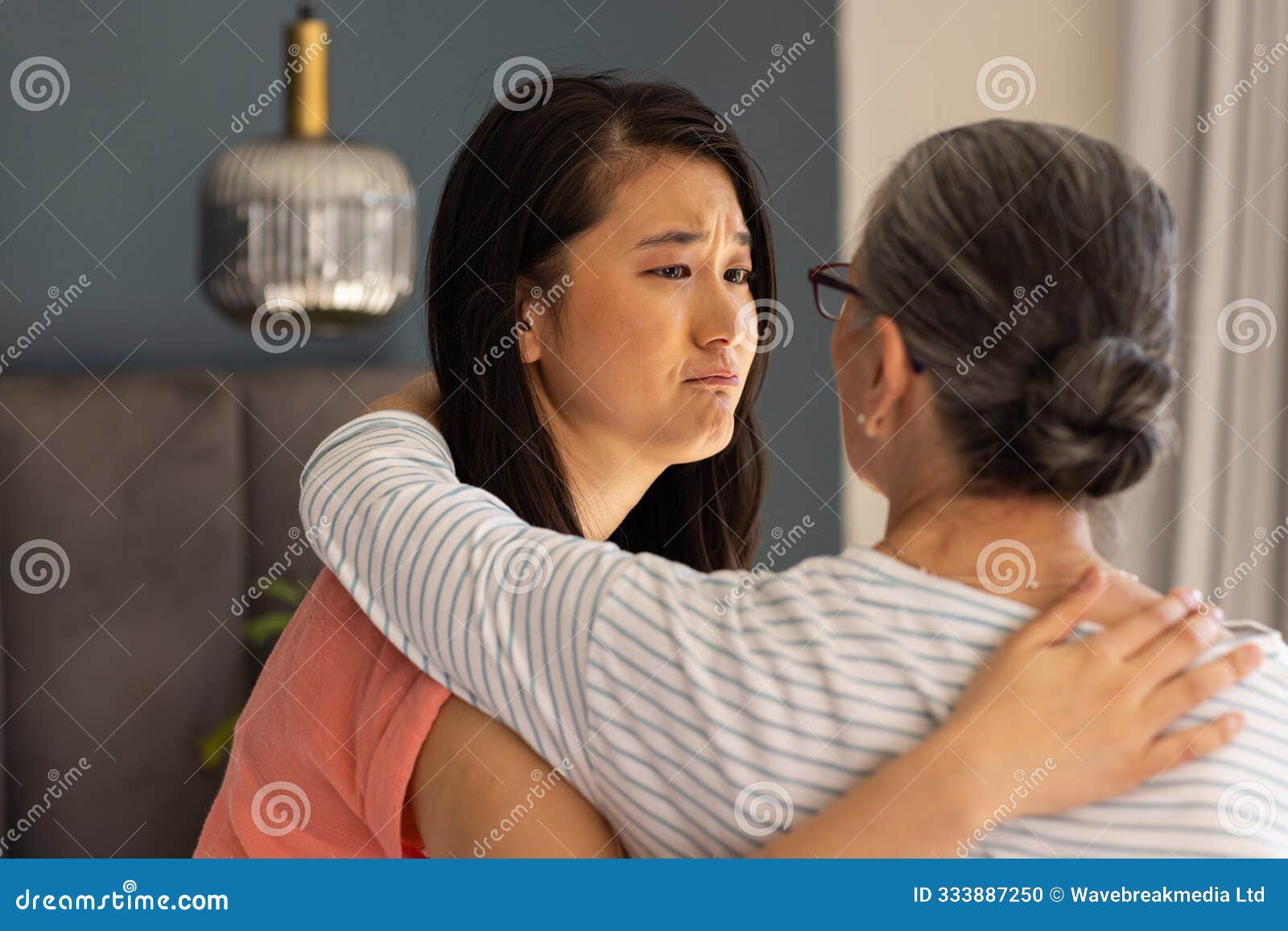 comforting each other,  asian grandmother and granddaughter sharing emotional moment at home