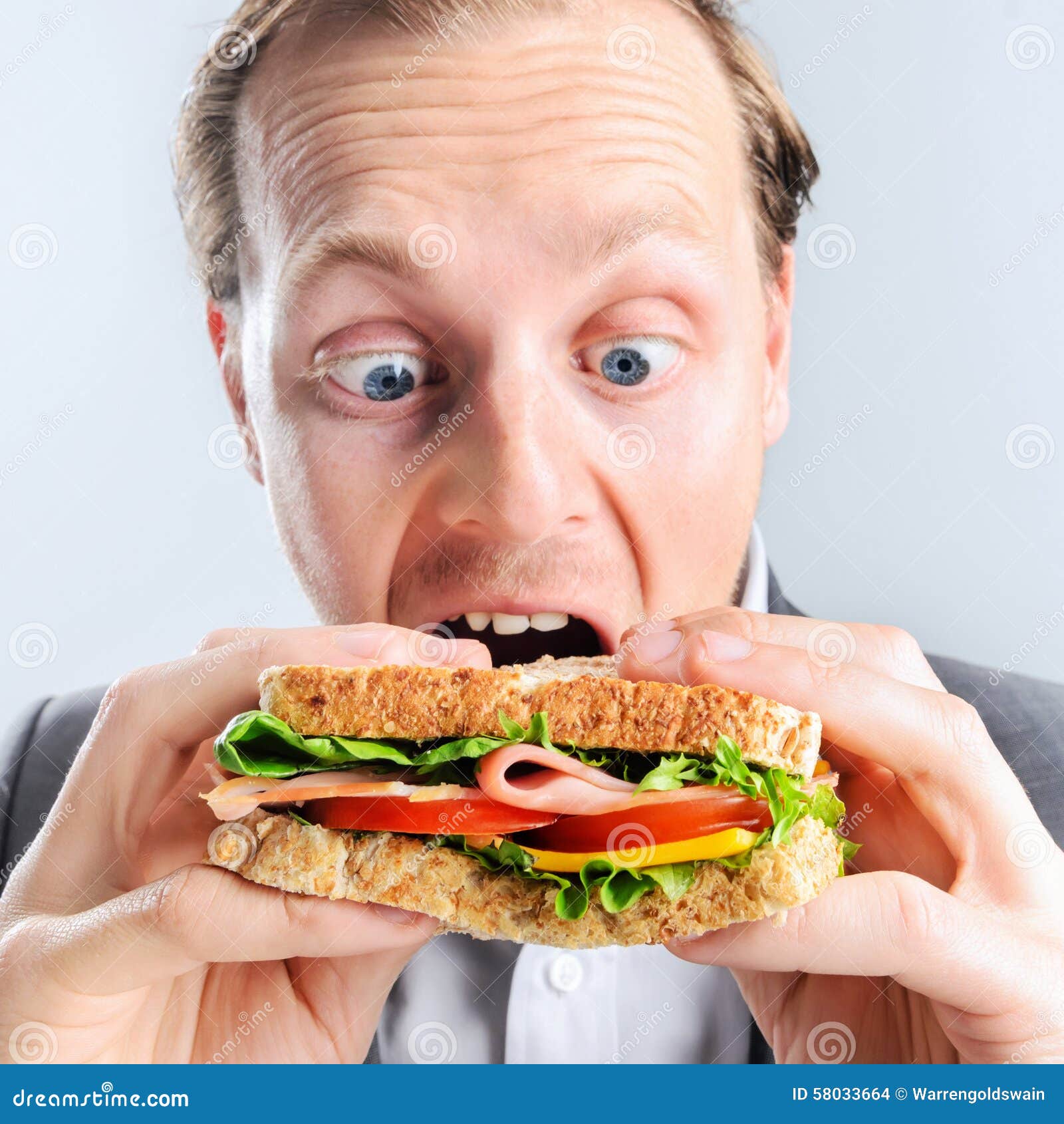 comical man eating sandwich with funny expression