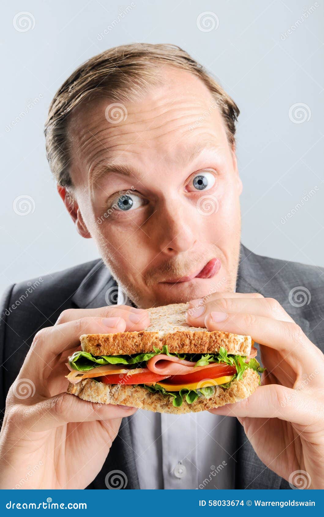 comical man eating sandwich with funny expression