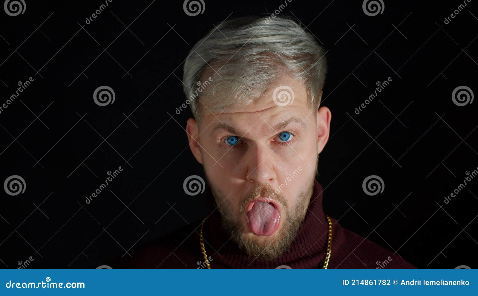 comical stupid stylish man making funny silly face grimace, playing fool, showing tongue, brainless