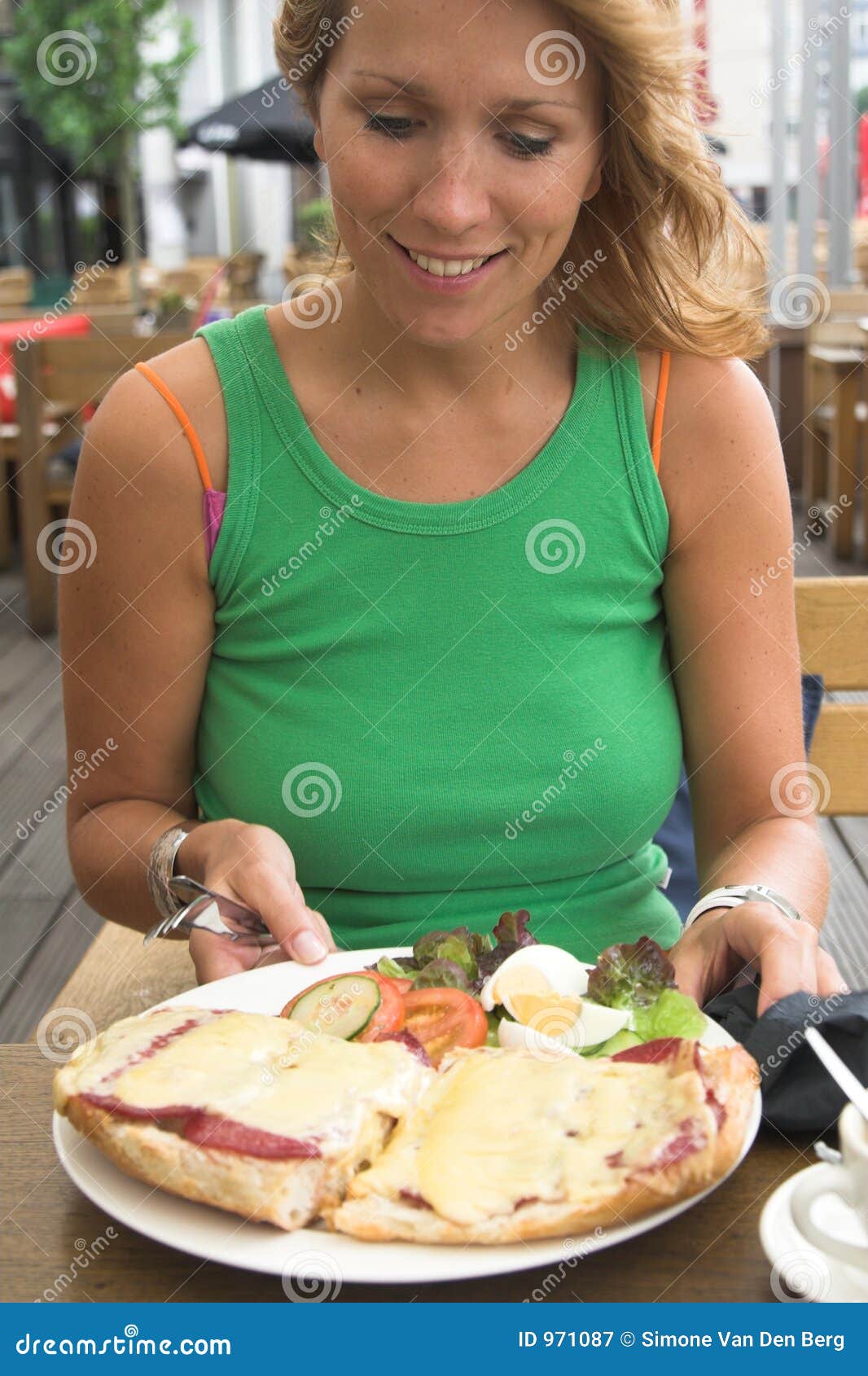 Comida feliz. Mujer rubia hermosa que parece muy feliz de recibir una placa por completo del alimento sabroso