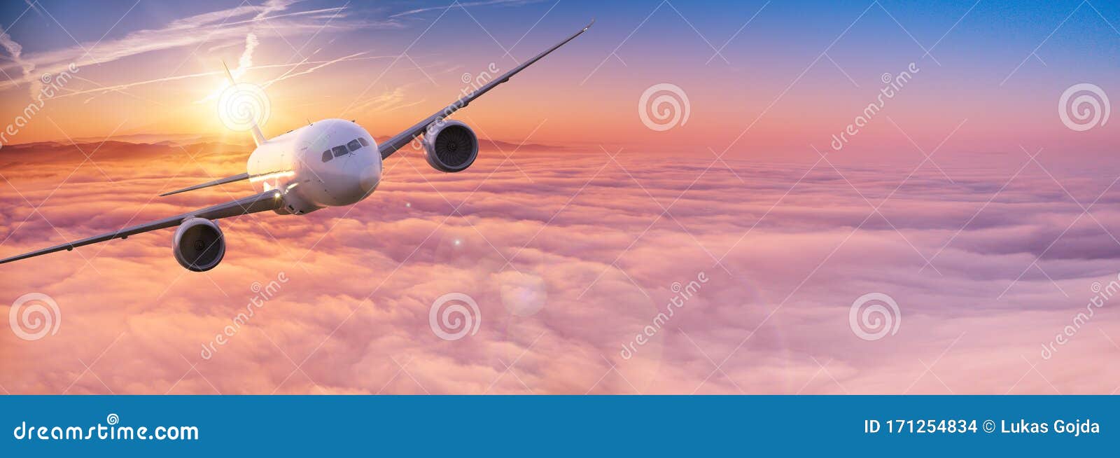 Commercial Airplane Jetliner Flying Above Dramatic Clouds. Stock Photo