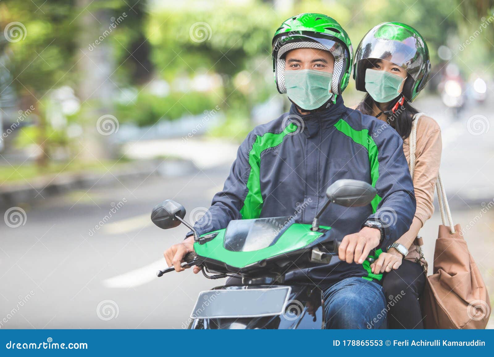 commercial motorcycle taxi driver taking his passenger to her de