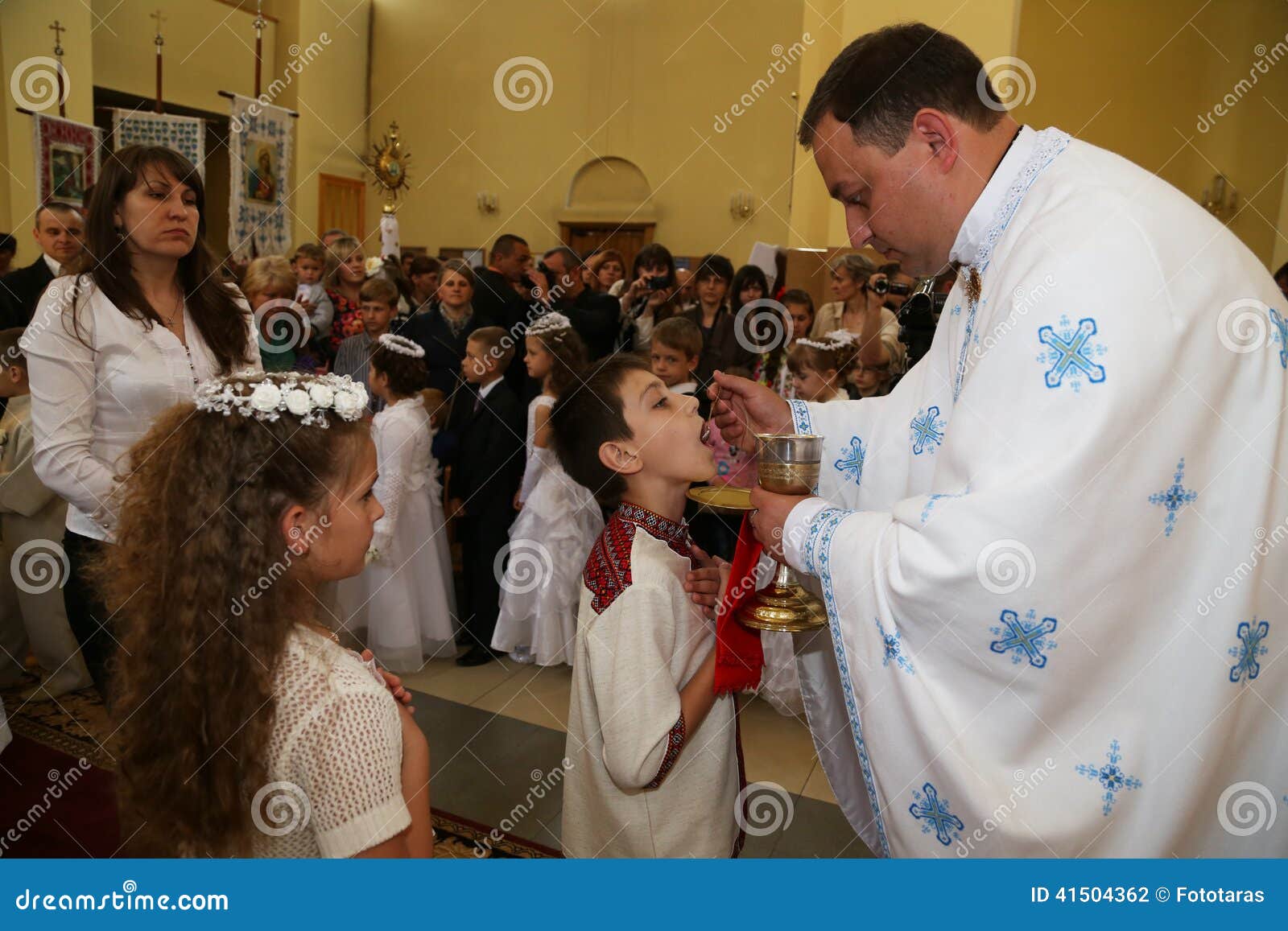 Communion. Lviv, de Oekraïne in 2014 Heilige Communie voor kinderen in de Griekse Katholieke Kerk