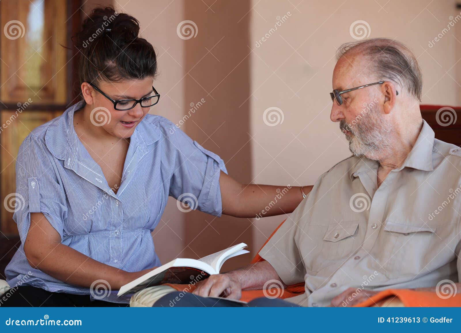 companion or granchild reading to senior or grandfather