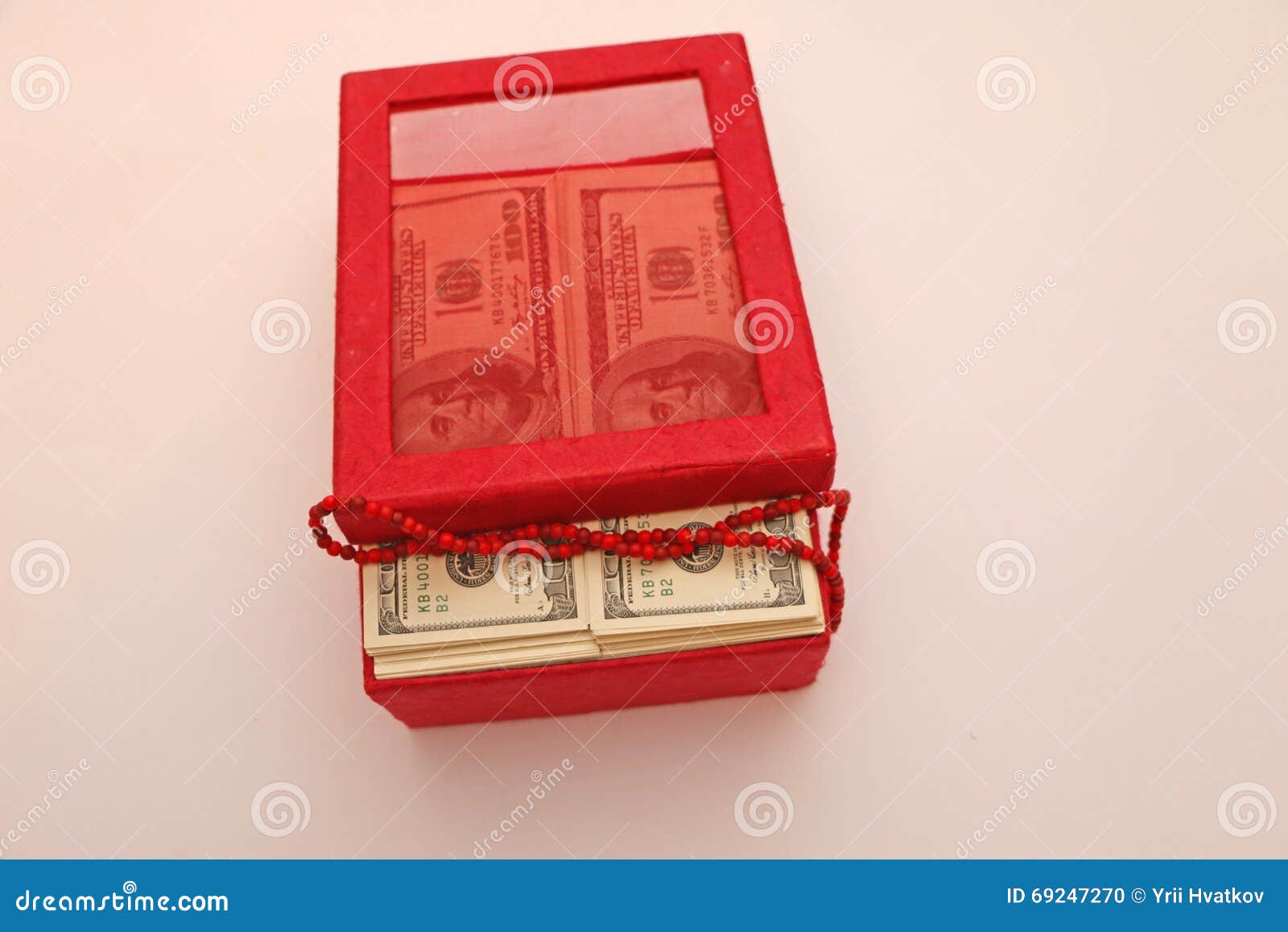 Composición. Los billetes de dólar doblaron en una cubierta de caja roja, gotas en billetes de banco