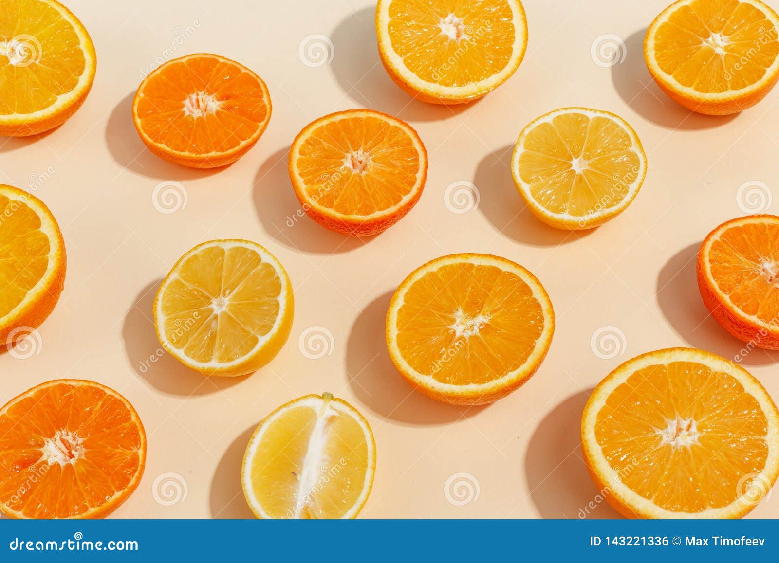 Composition of Citrus Fruits Cut in Half on a Light Yellow Background