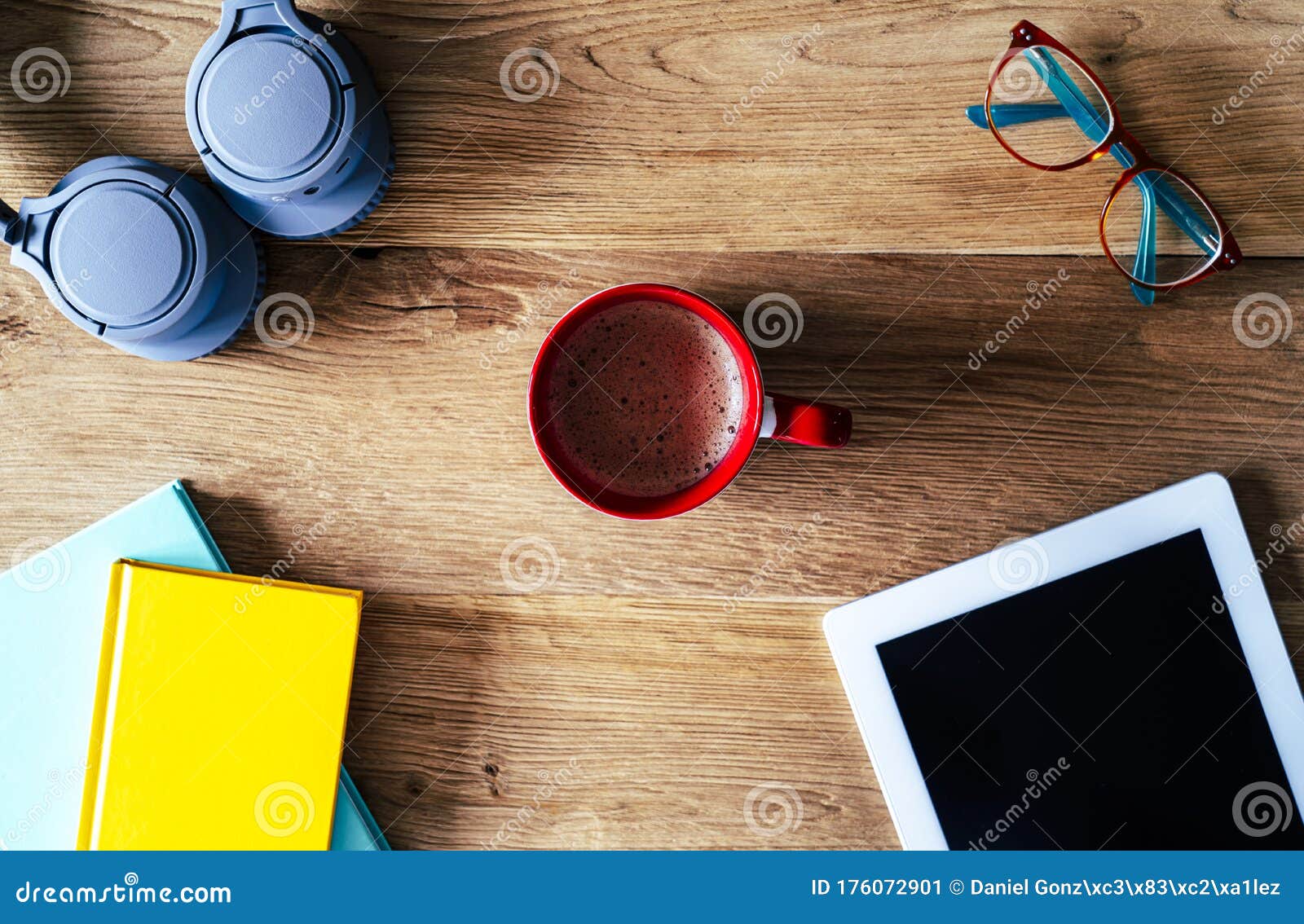 composition of tablet notebooks headphones and coffee on a desk with wooden background