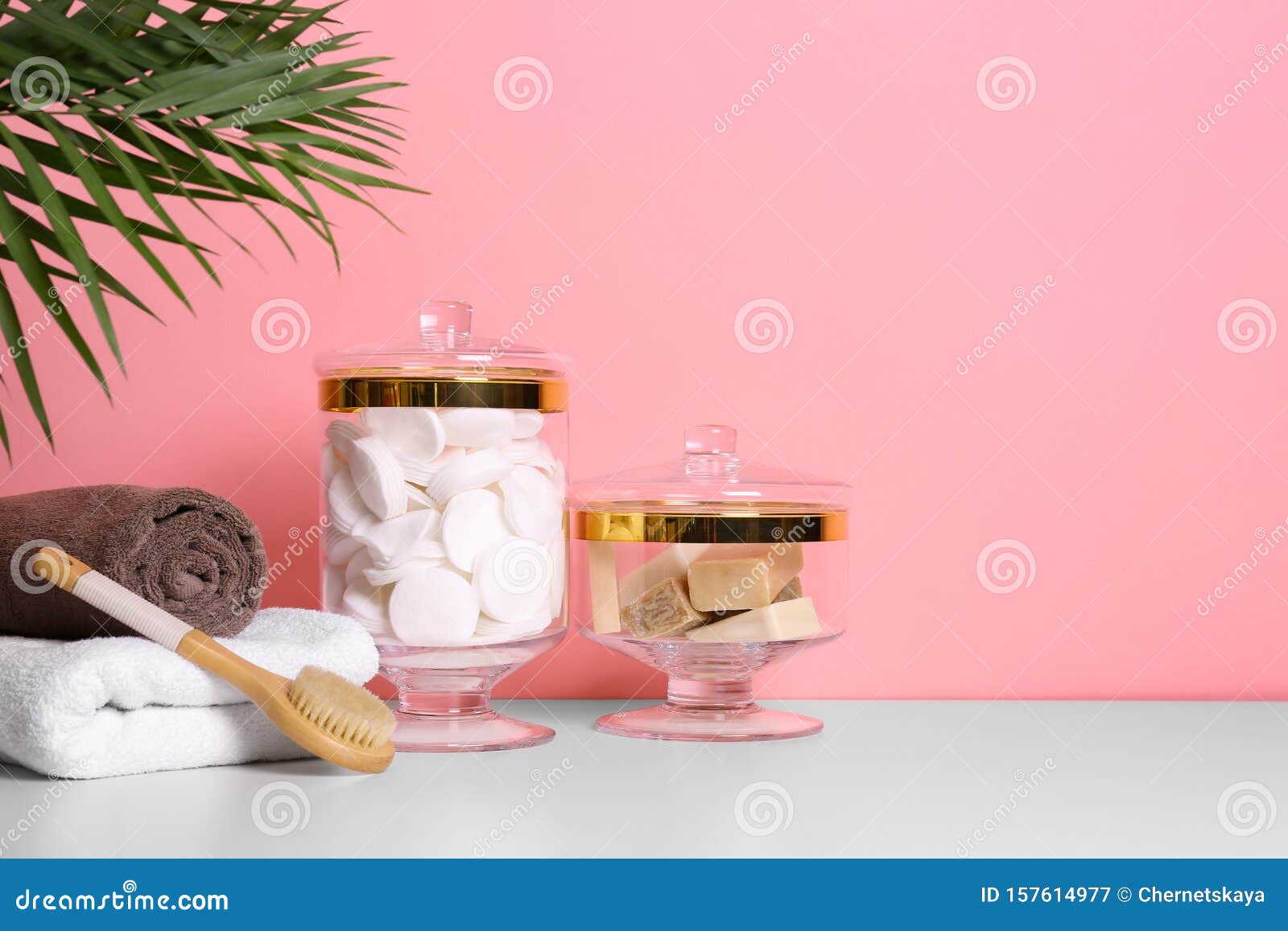 Composition of Glass Jar Cotton Pads on Table Near Pink Wall. Space for