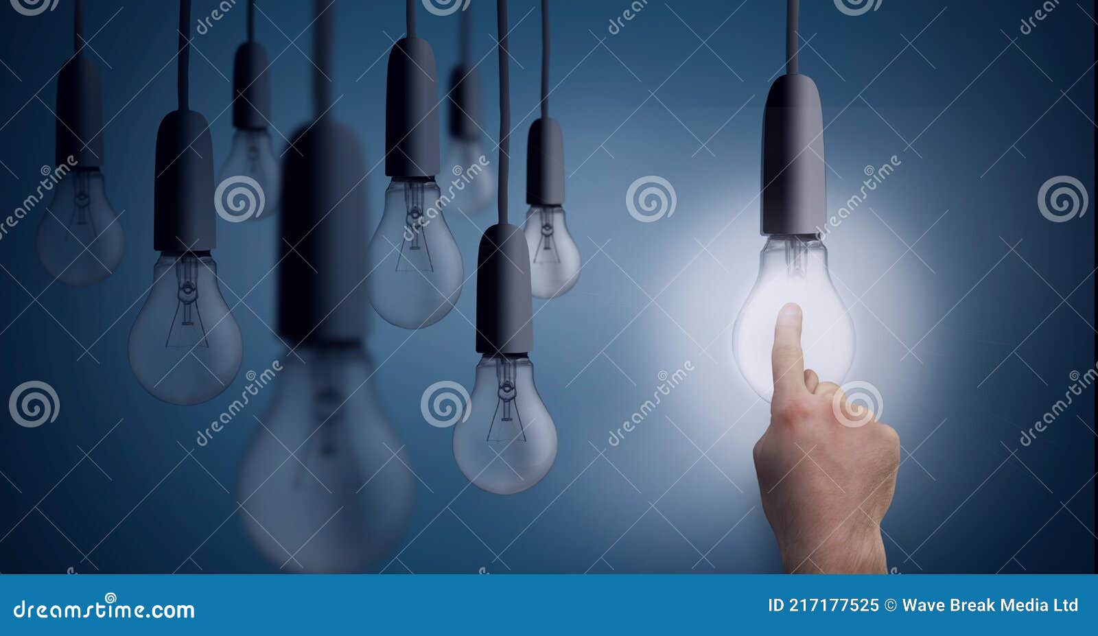 Composition of Multiple Light Bulbs Hanging with Finger Touching Lit Light Bulb on Blue