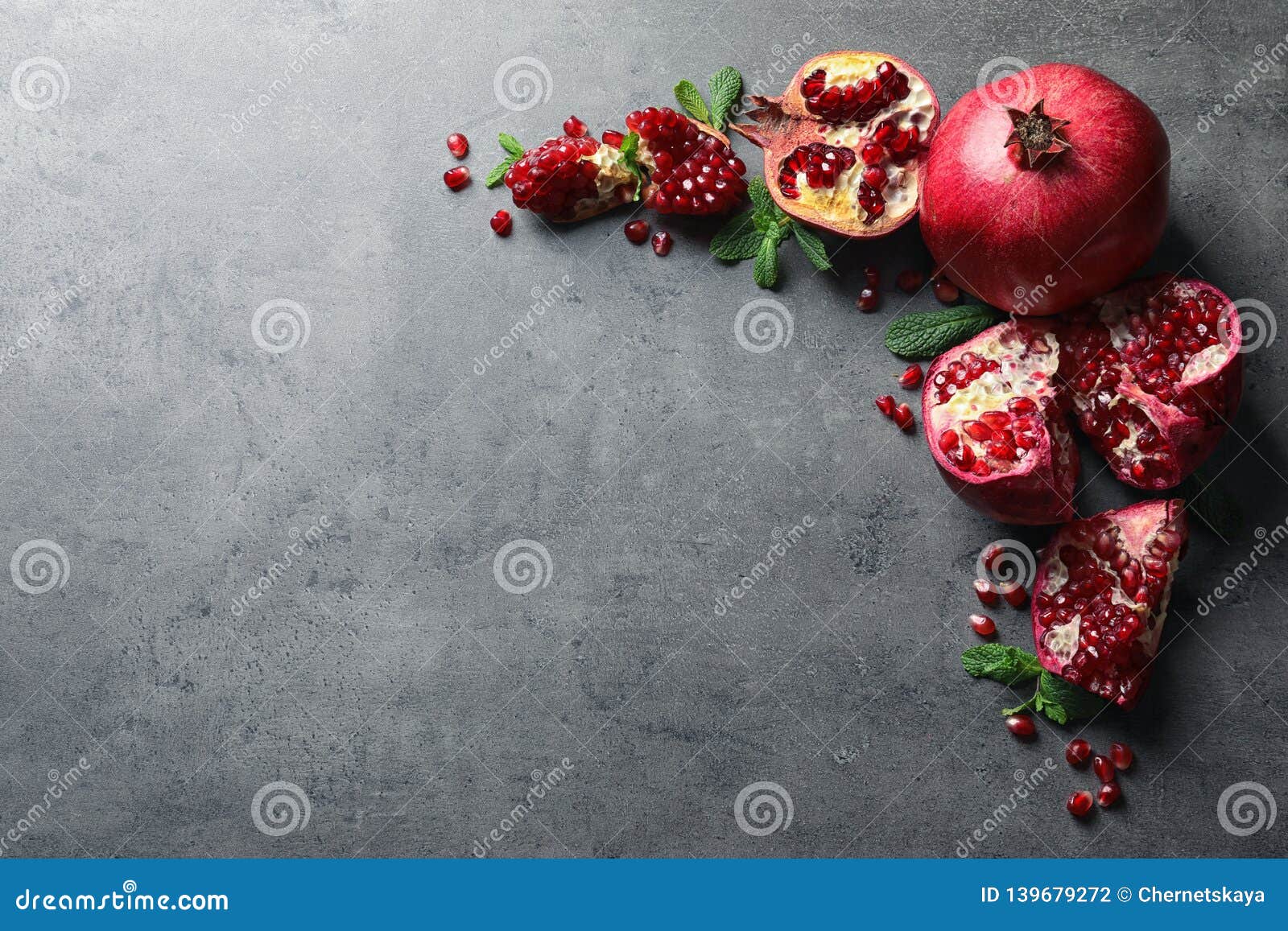 composition with ripe pomegranates and space for text on grey background