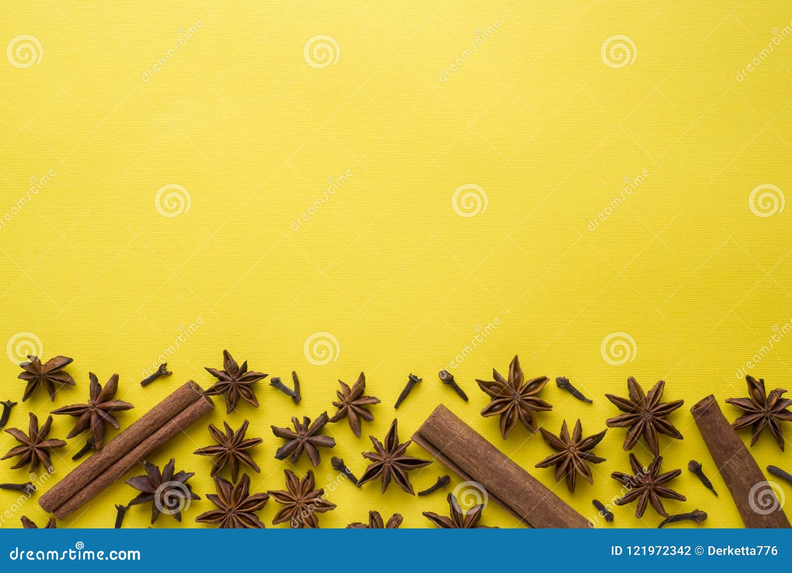 composition of star anise, cinnamon sticks and cloves on a yellow background. abstract flat pattern, top view