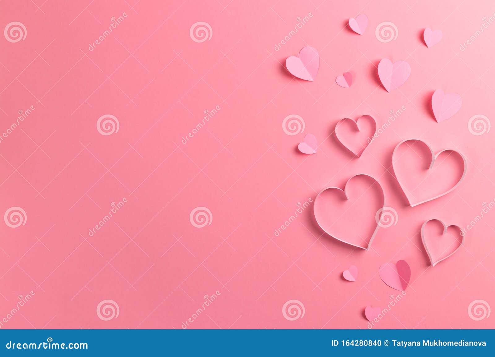 composition for valentine`s day february 14th. delicate pink background and pink hearts cut out of paper. greeting card